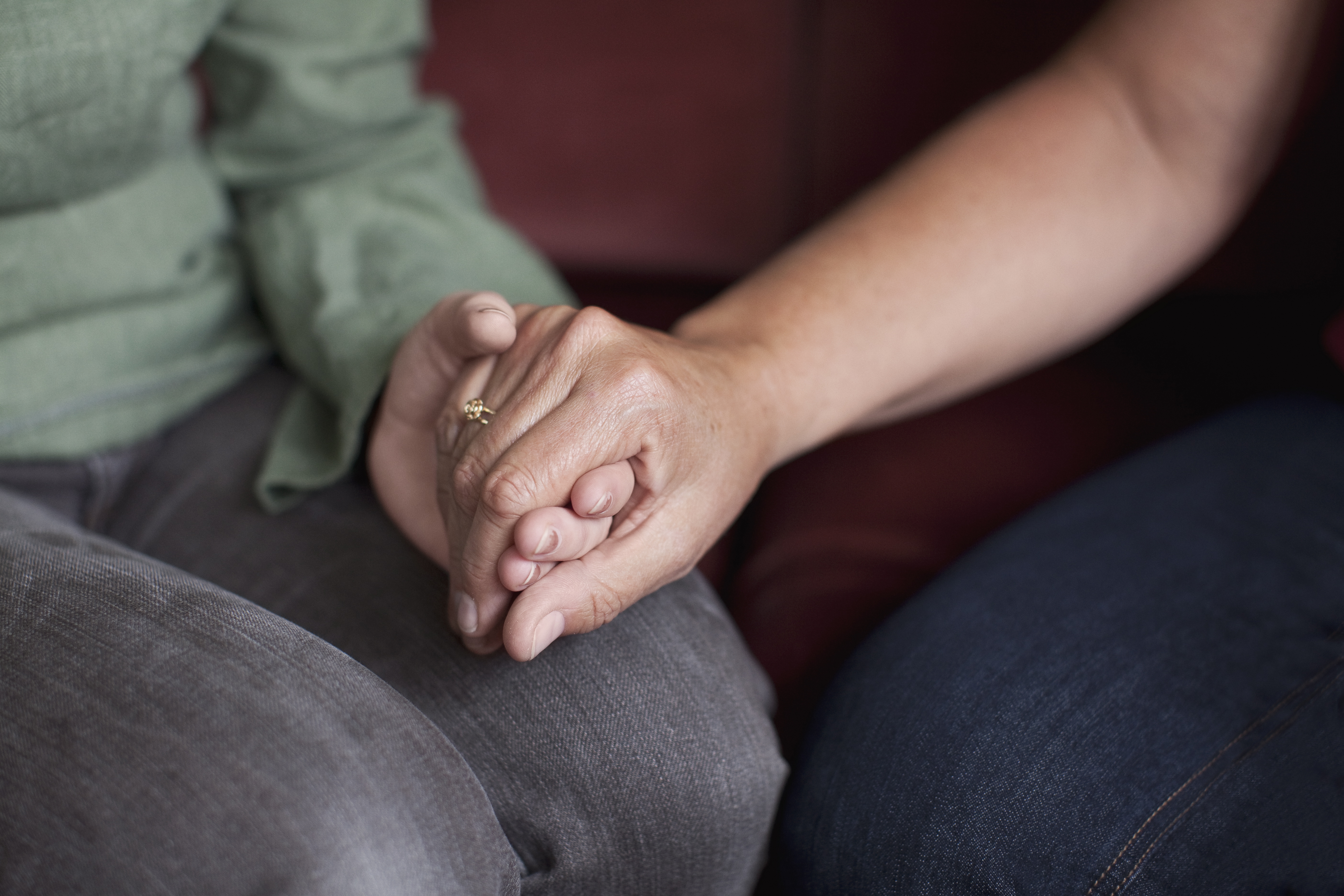 En hand som håller en annan hand i en tröstande gest.