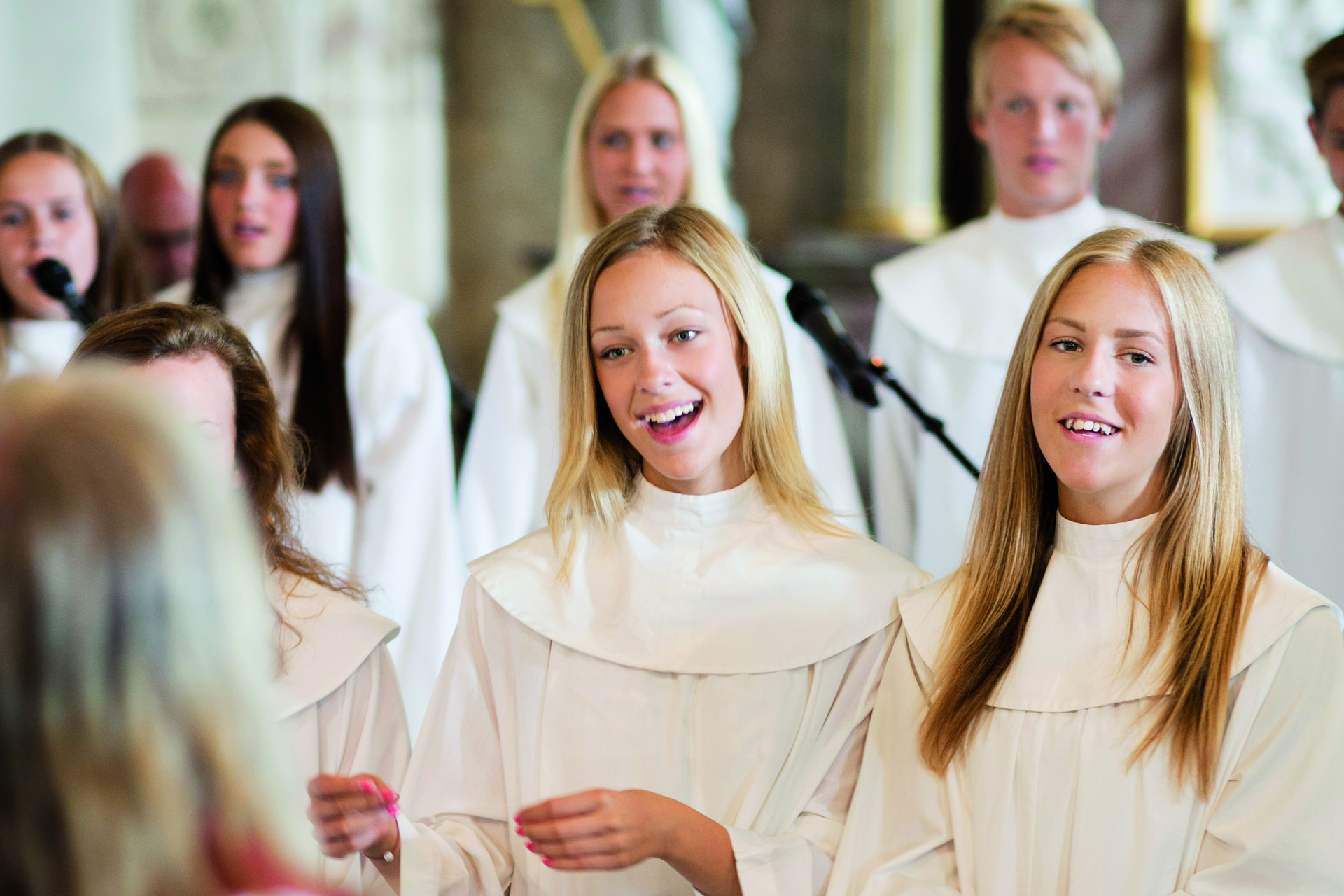 Ett antal ungdomar, klädda i konfirmanddräkter samlade. De ser glada ut. 