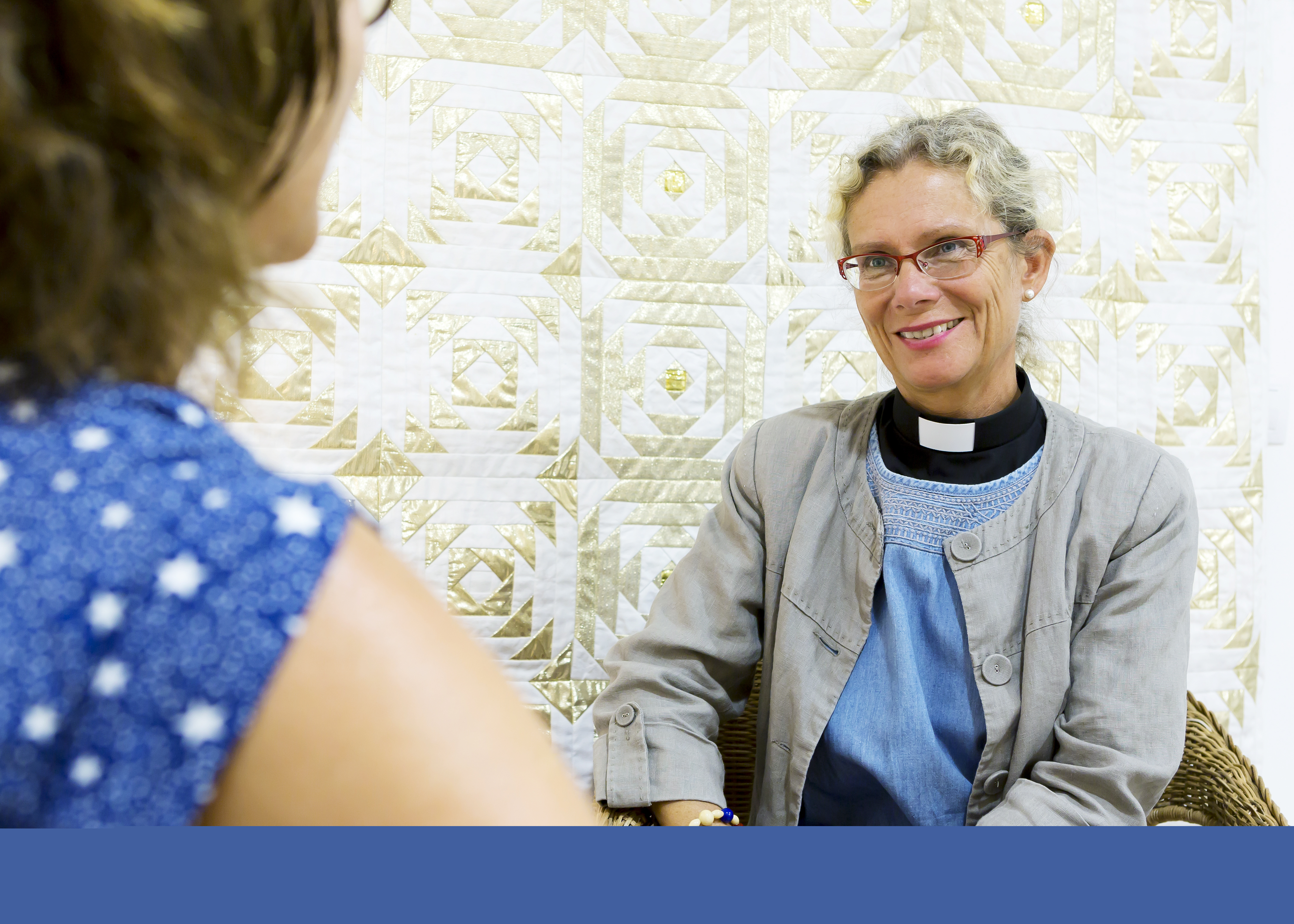 En präst sitter i enskilt samtal med en person.