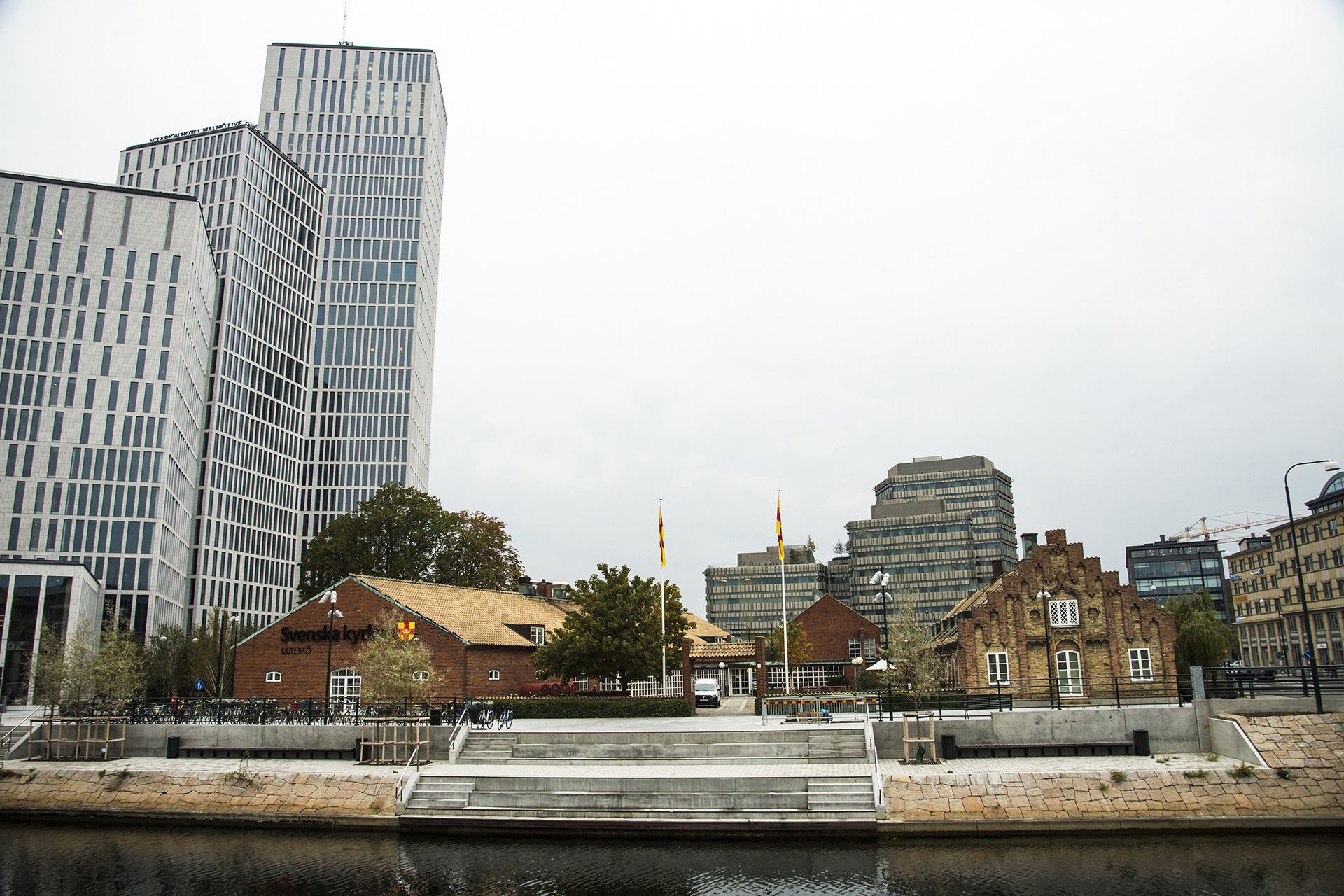 Låga gamla tegelbyggnader flankerade av moderna byggnader. 