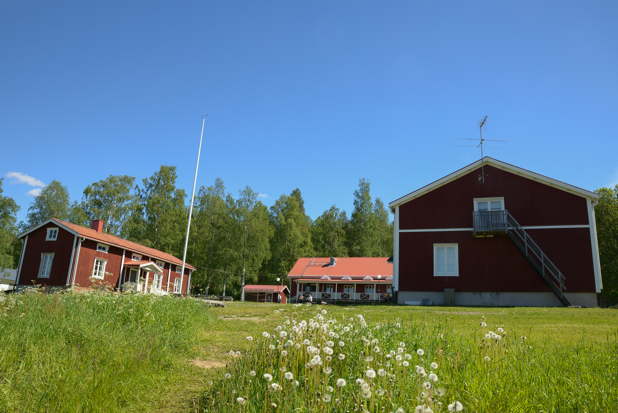 Husen på Kyrkans lägergård med Husmorsvillan till vänster, huvudbyggnaden i mitten och logementet till höger