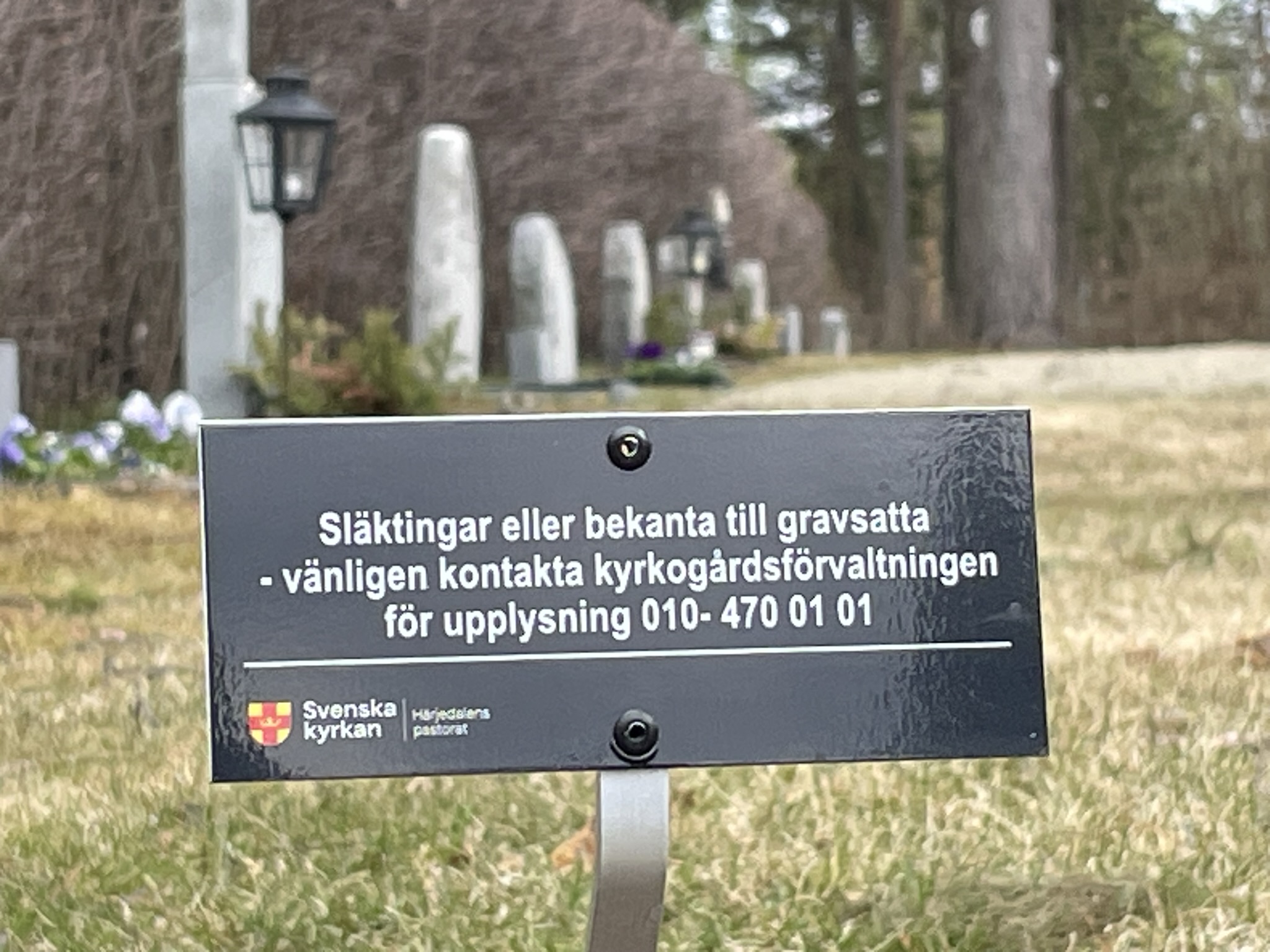 Skylt med uppmaning att kontakta kyrkogårdsförvaltningen