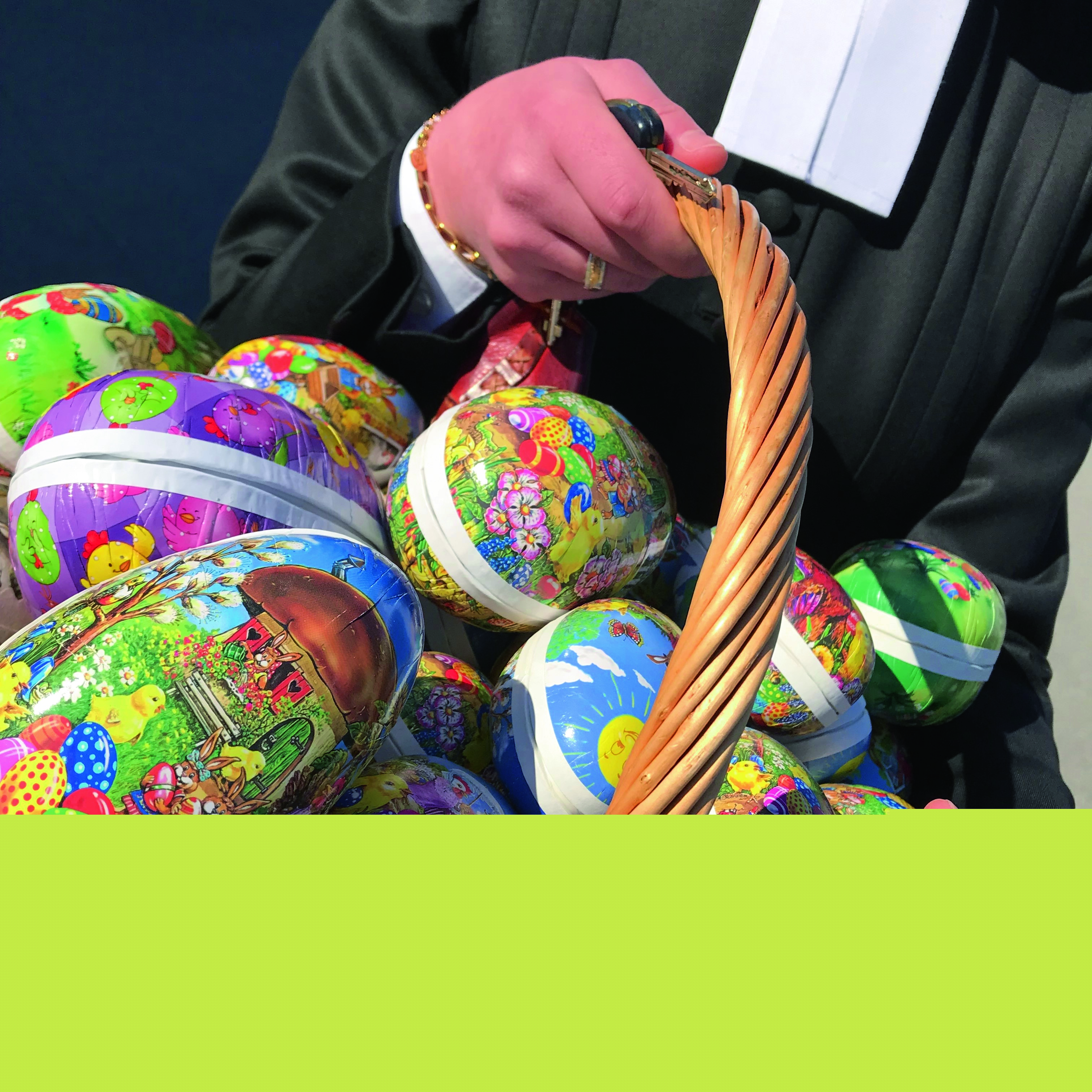 En präst håller en korg med påskägg.