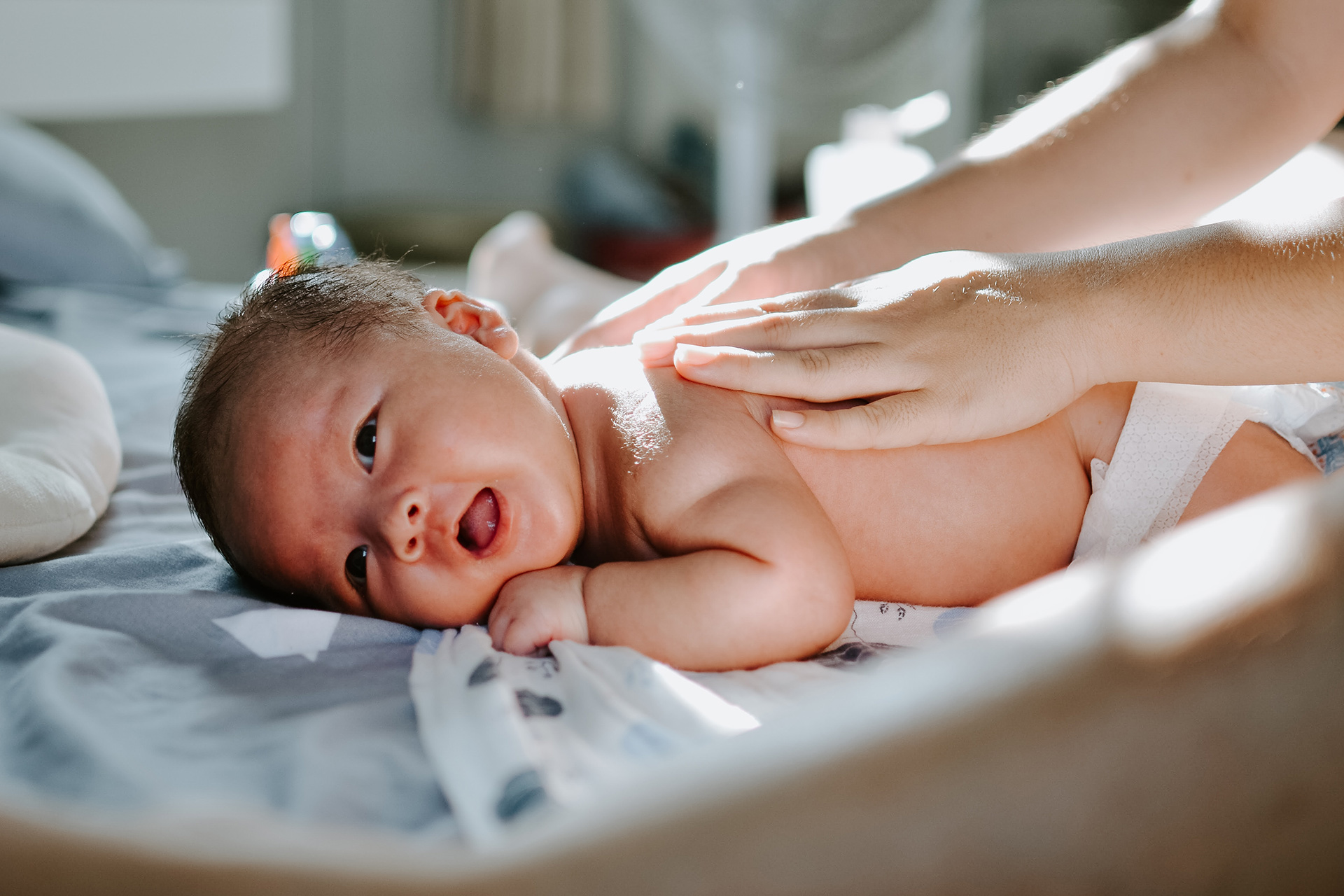 En baby på mage får massage på ryggen. 