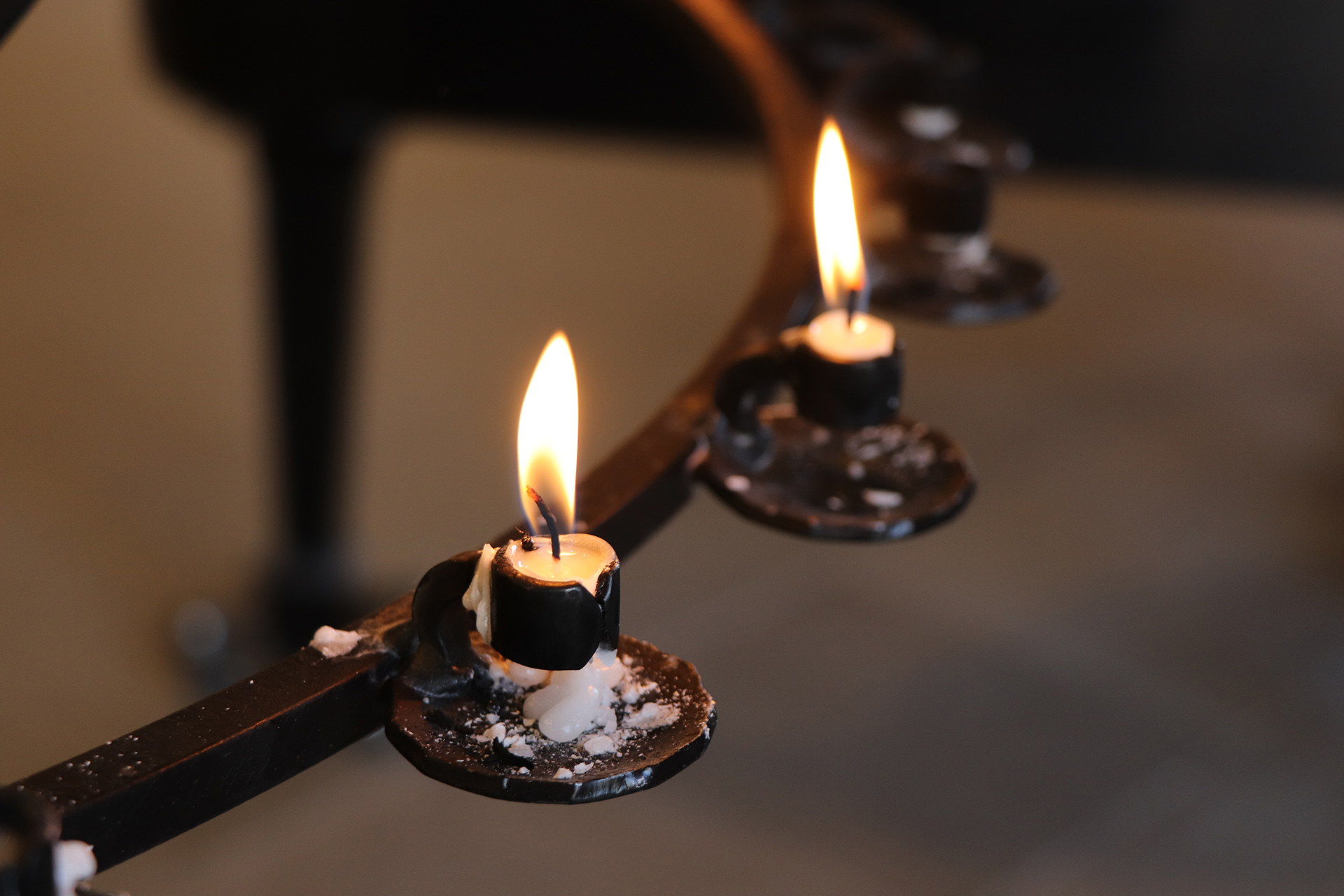 Två ljus brinner i en ljusbärare. 