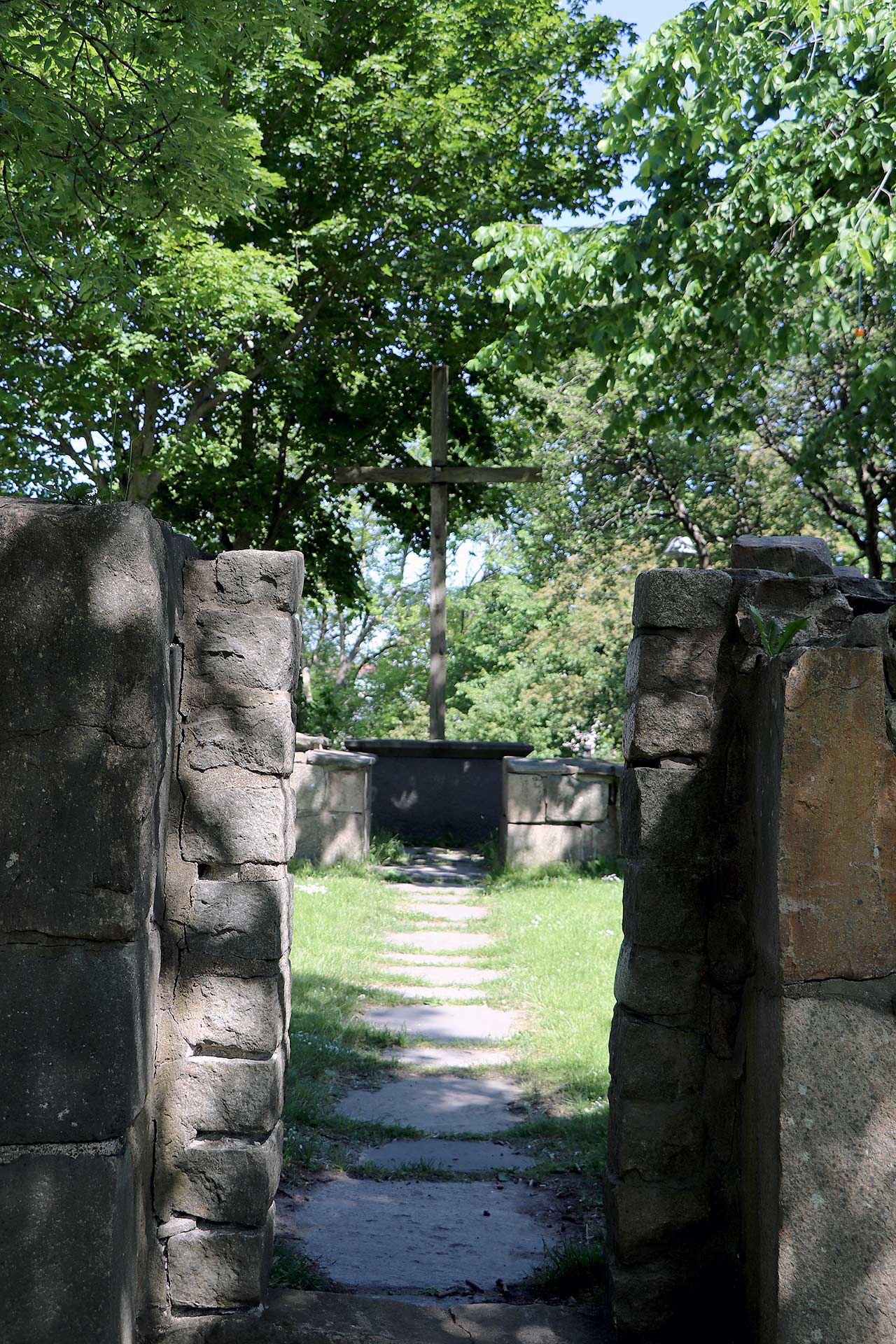 Ingången till Härlanda kyrkoruin där man ser korset och altaret längst in.