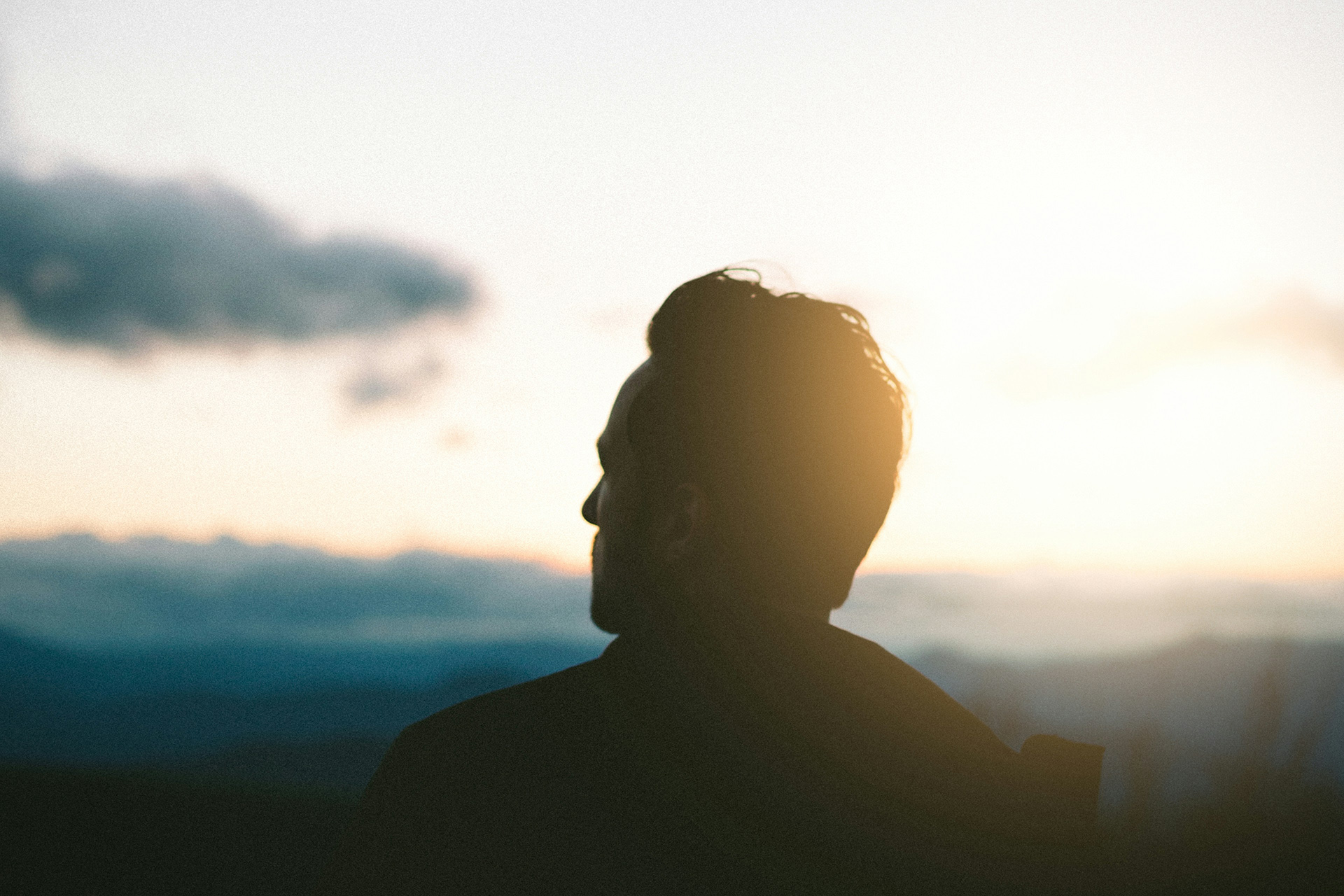 Silhuett av en person som tittar ut över horisonten.