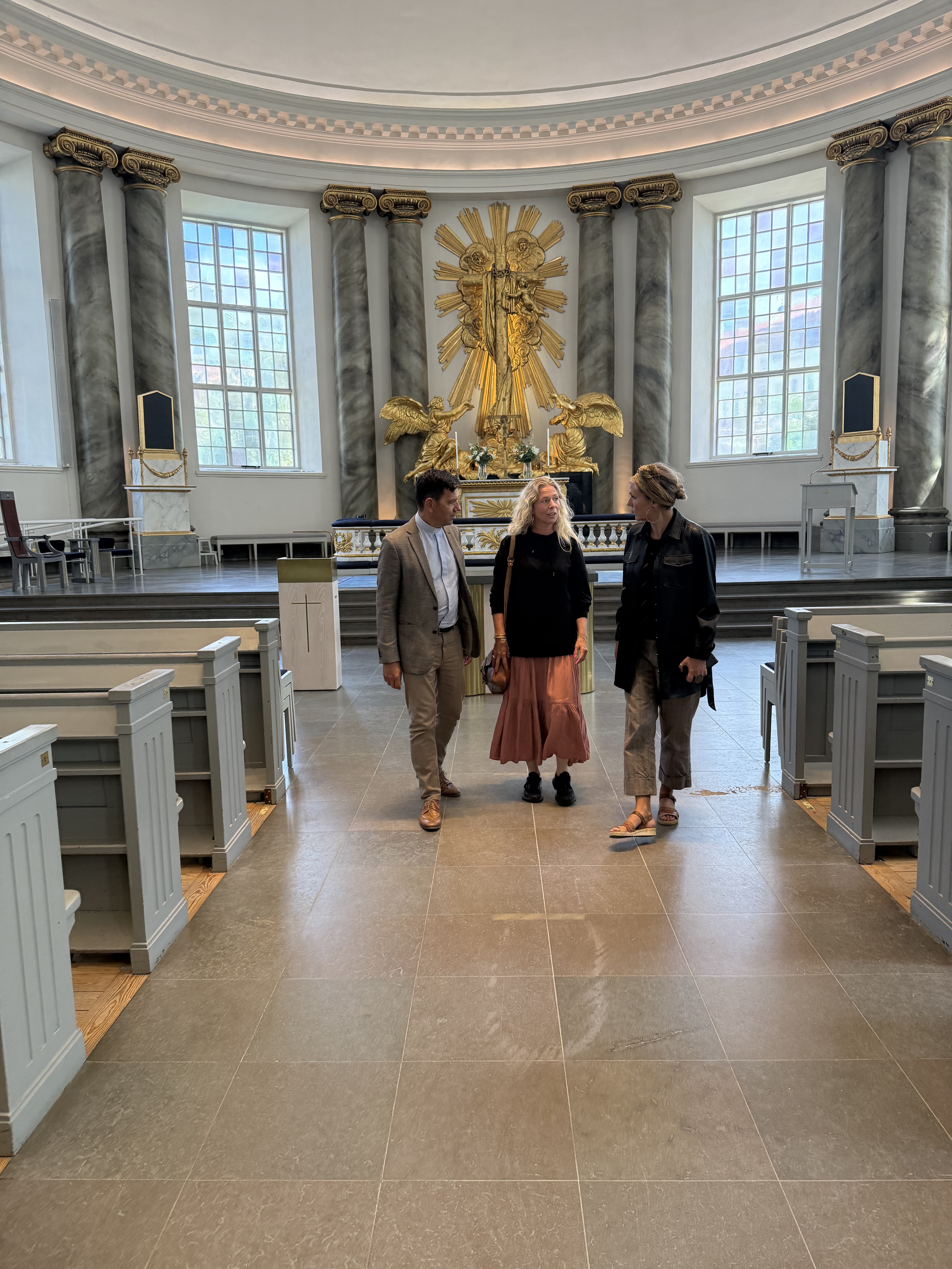 Stefan Hiller, Charlotte Råwall och Malin Aghed går och pratar i mittgången i Göteborgs domkyrka