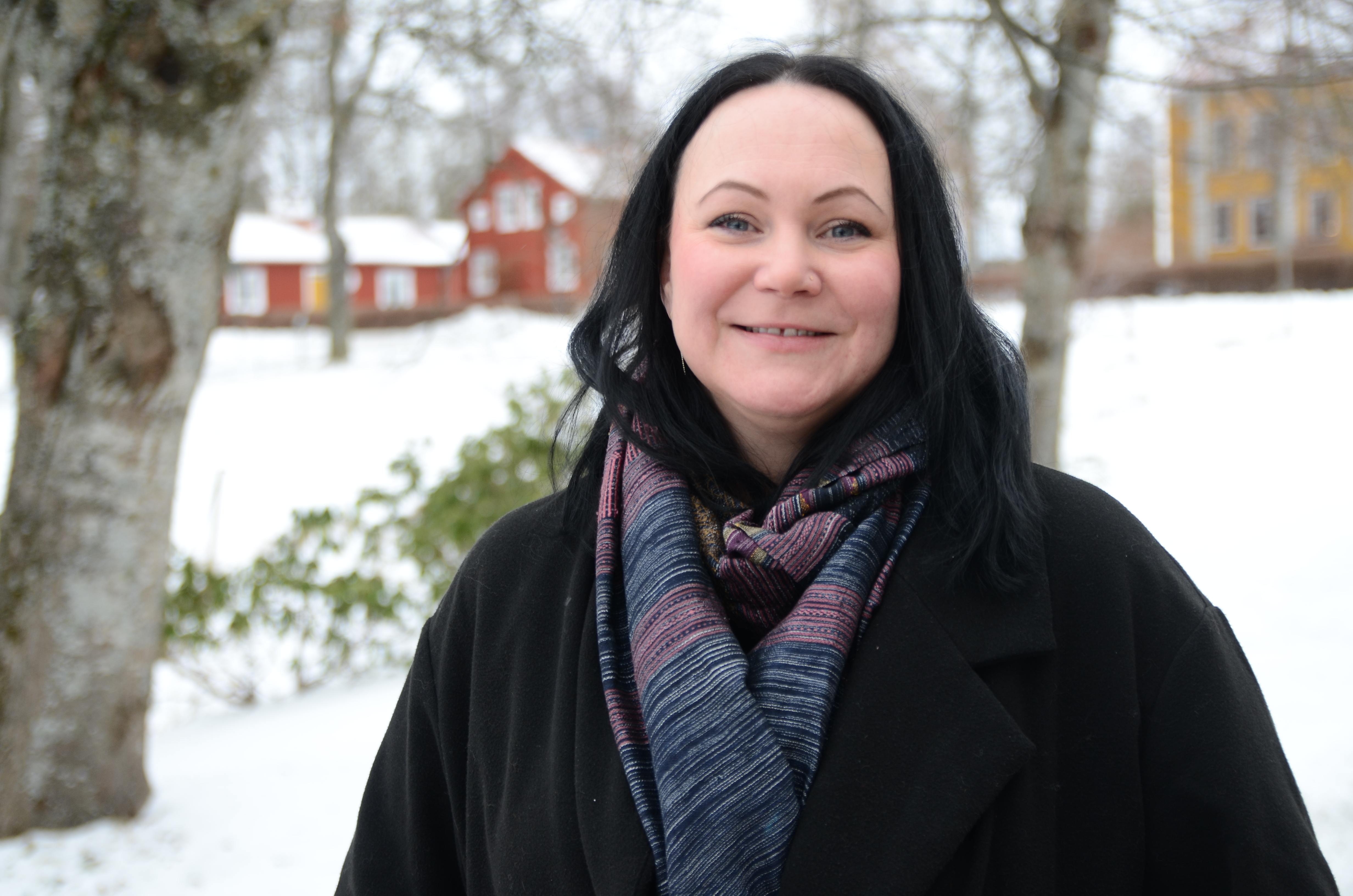 Porträttbild på Johanna Salomonsson. I bakgrunden syns ett snöigt Östrabo.