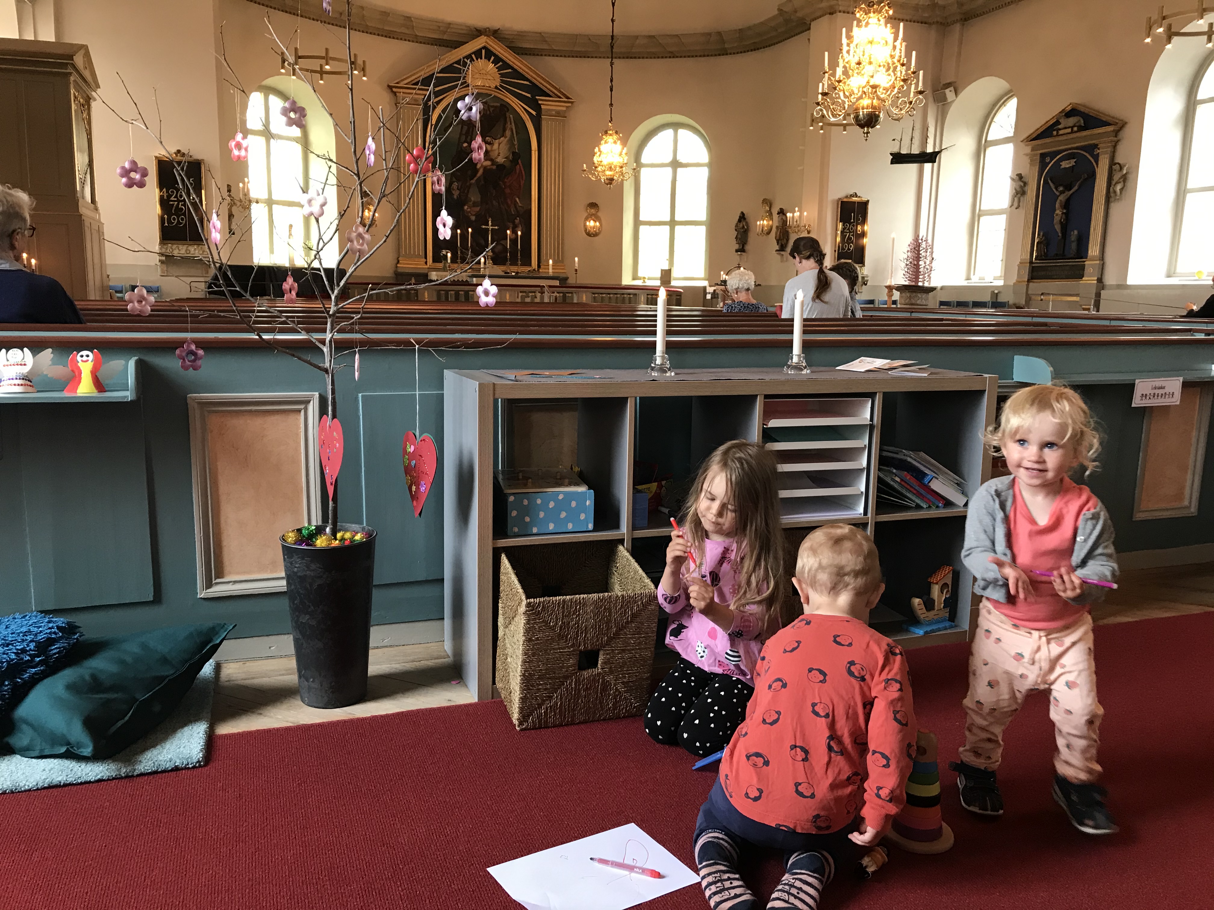 Ellen, Lilly och Sakarias leker i barnhörnan i Mönsterås kyrka. Barnhörnan är placerad i mitten av kyrkan. Placeringen möjliggör för barn och föräldrar att aktivt delta i gudstjänsten och samtidigt hålla fingrarna sysselsatta.