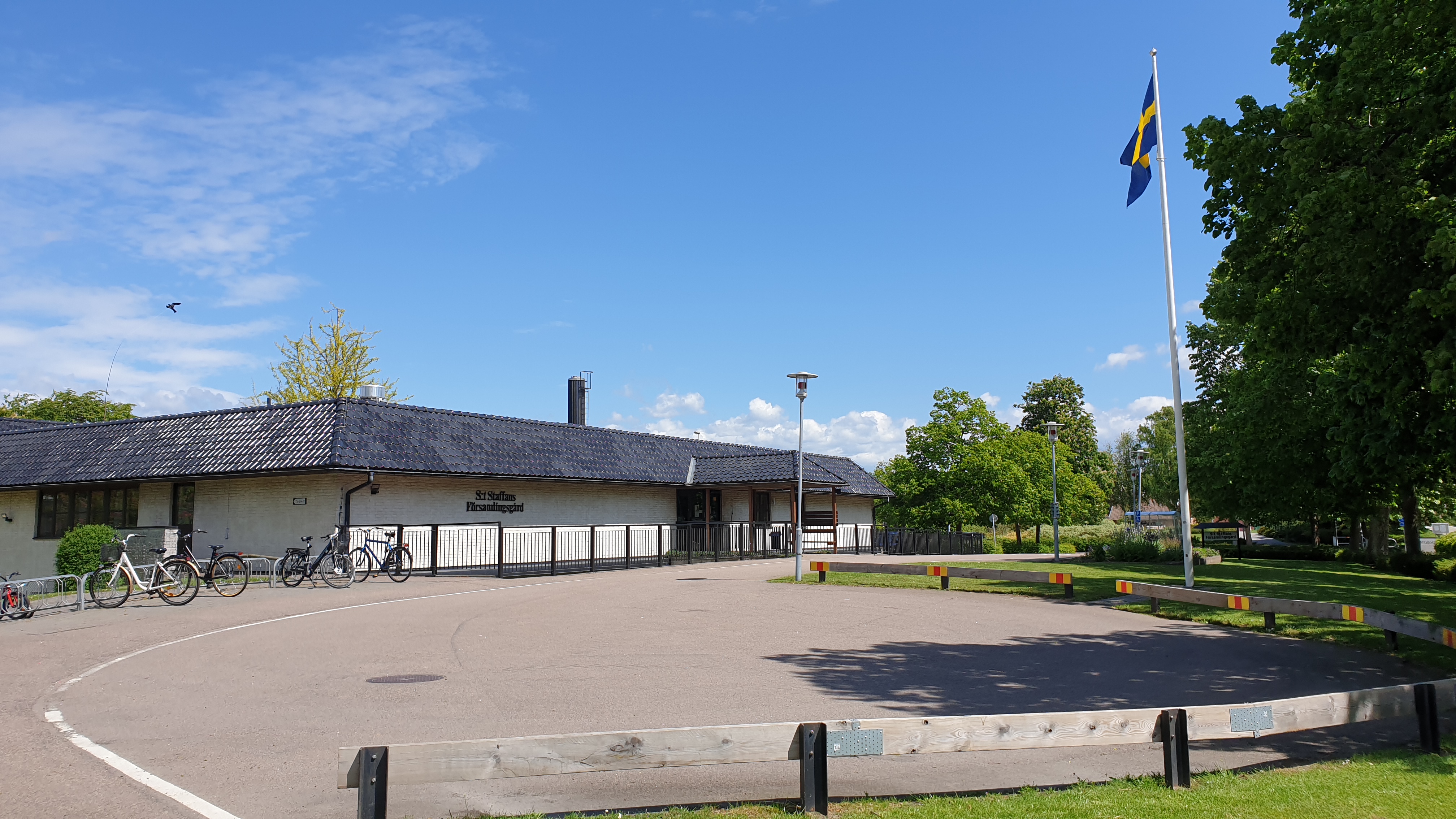 S:t Staffans församlingsgård en solig dag med svenska flaggan hissad.
