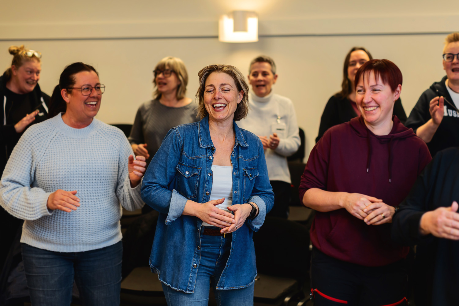 Tre kvinnor som står och sjunger och dansar.