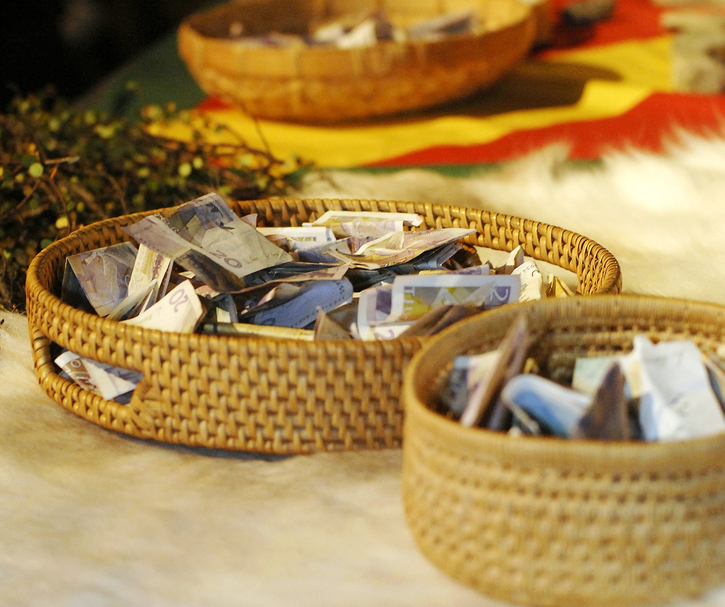 Korgar fyllda med sedlar står på ett bord.