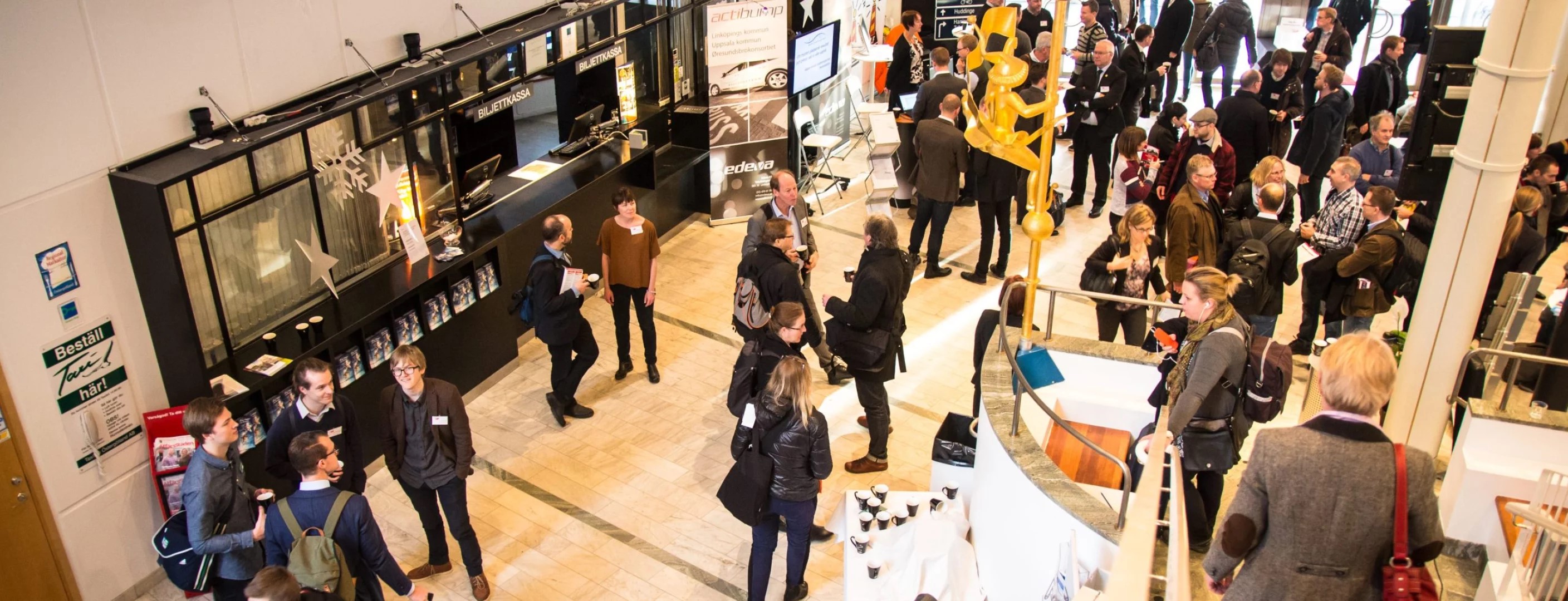 Översikt av ett ljust rum med människor som minglar.