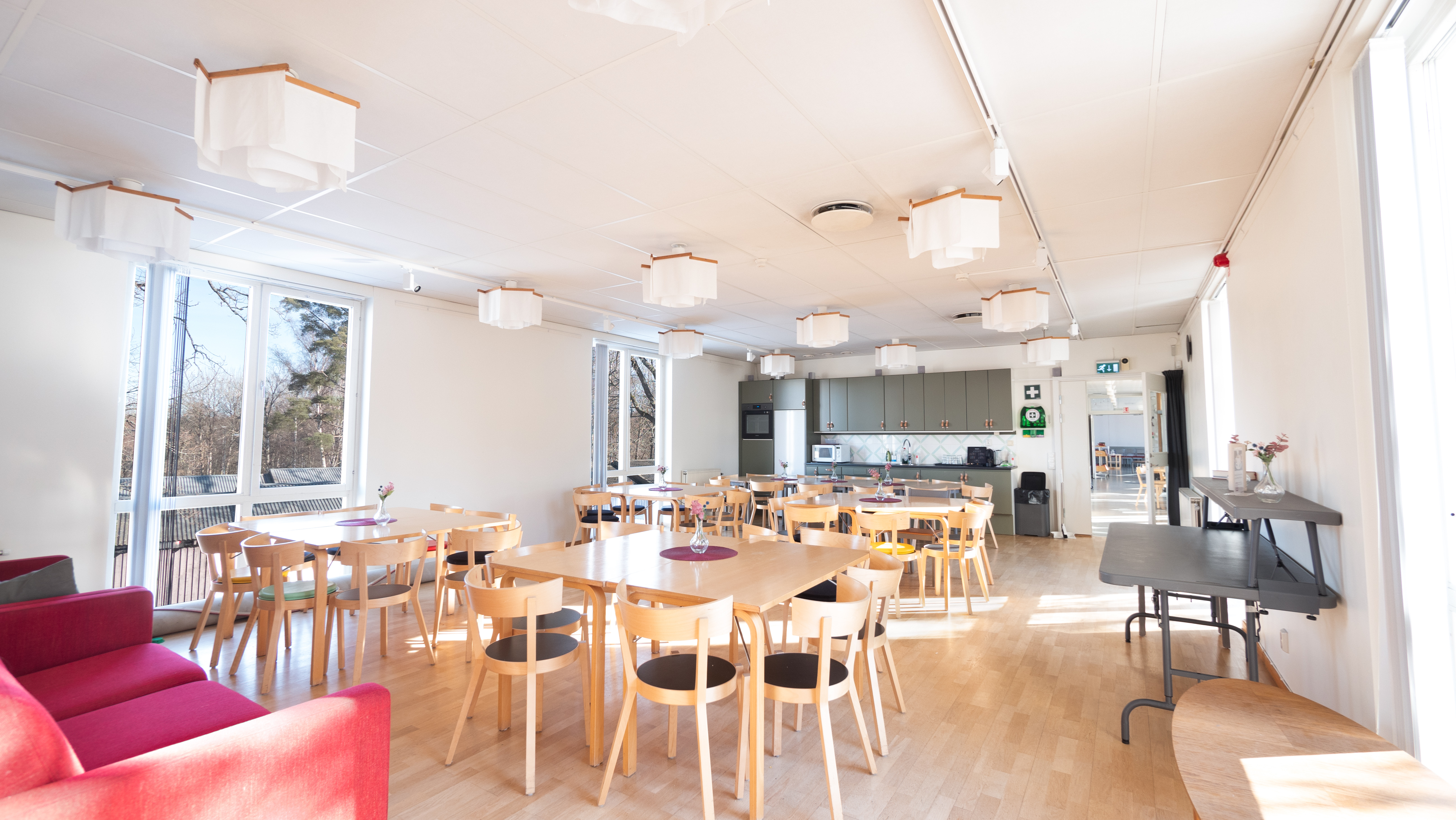 Rum fyllt med bord och stolar.