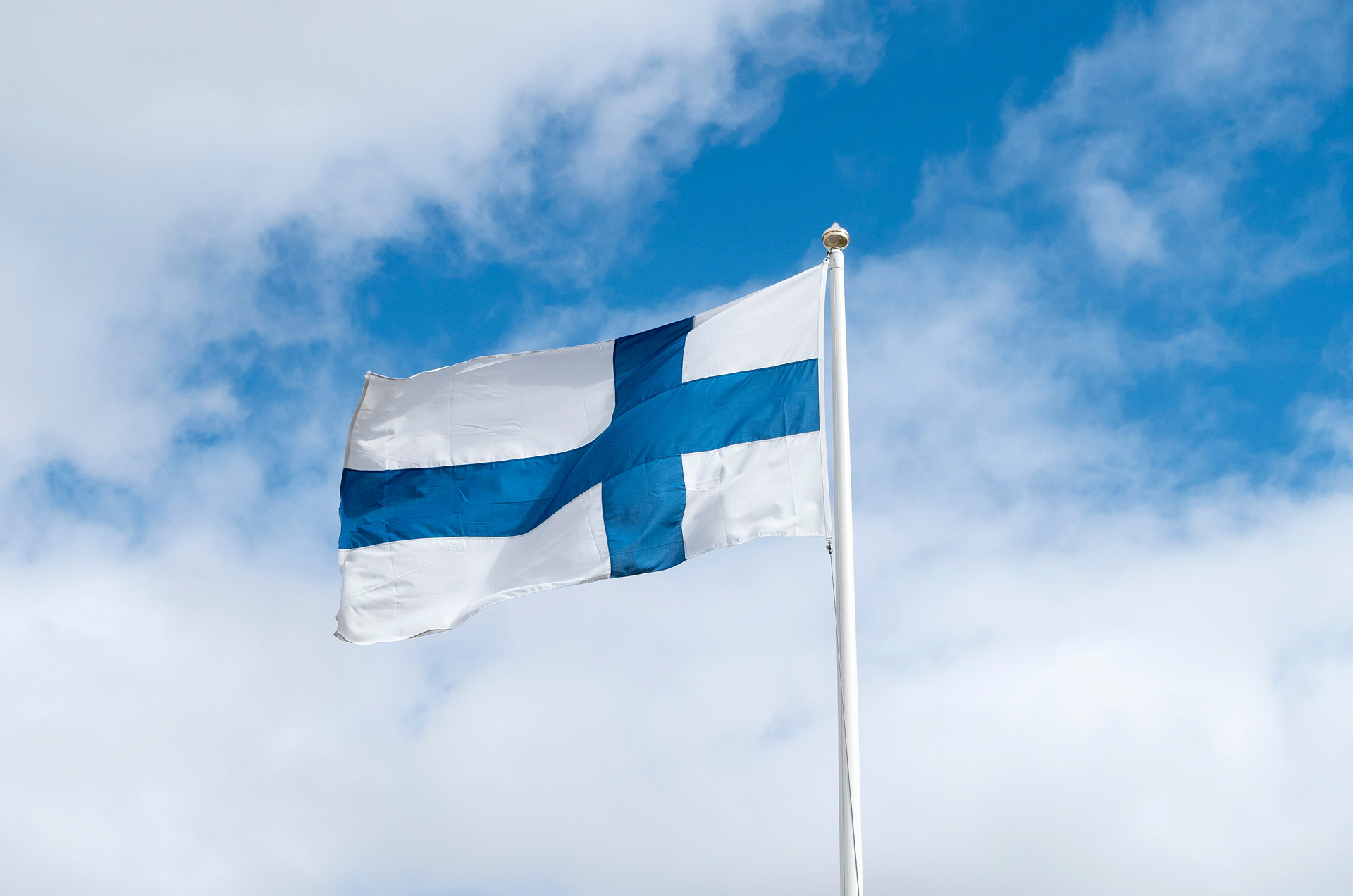 Finlands flagga mot himmel med moln