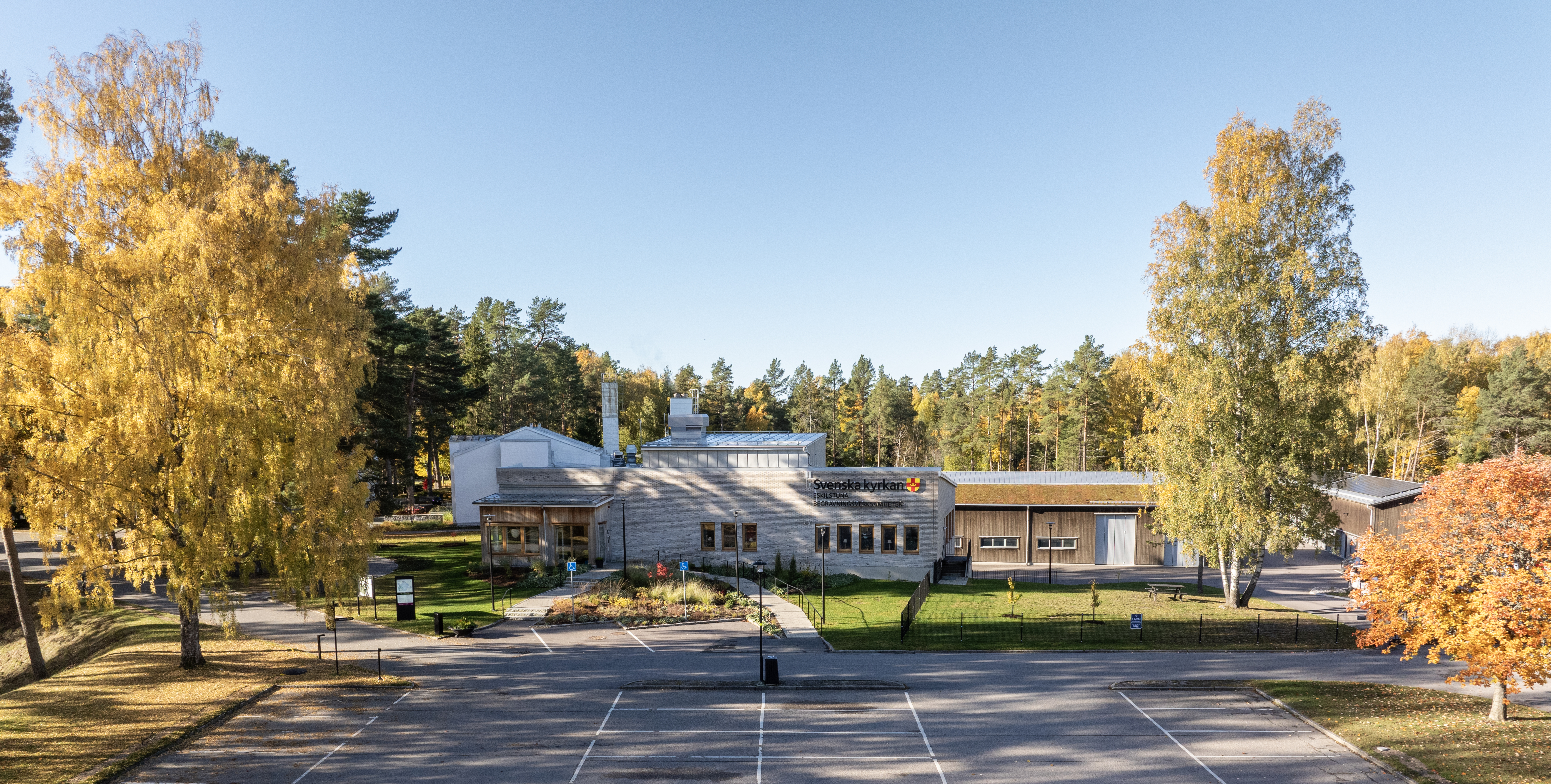 Eskilstuna krematorium med höstfärgade träd intill.