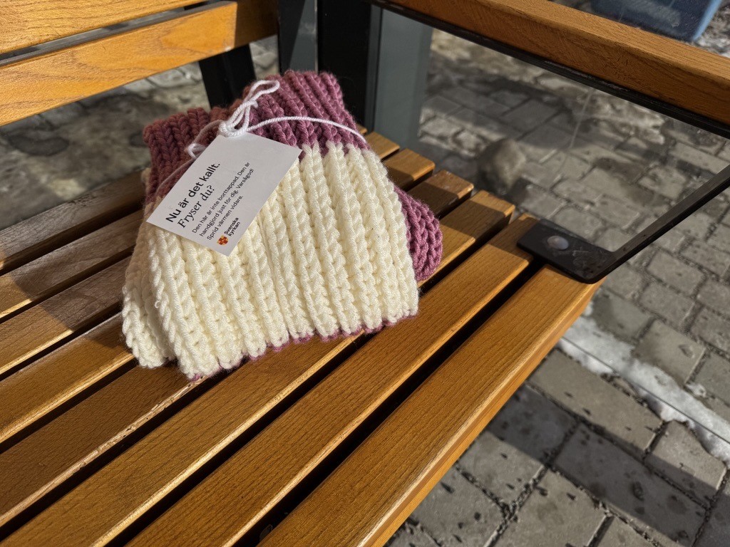 En halsduk som skänks på en bänk i en busskur i kampanjen Ett varmare samhälle