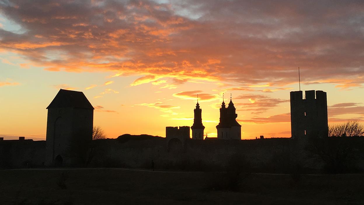 Kyrktorn och ringmur i solnedgången