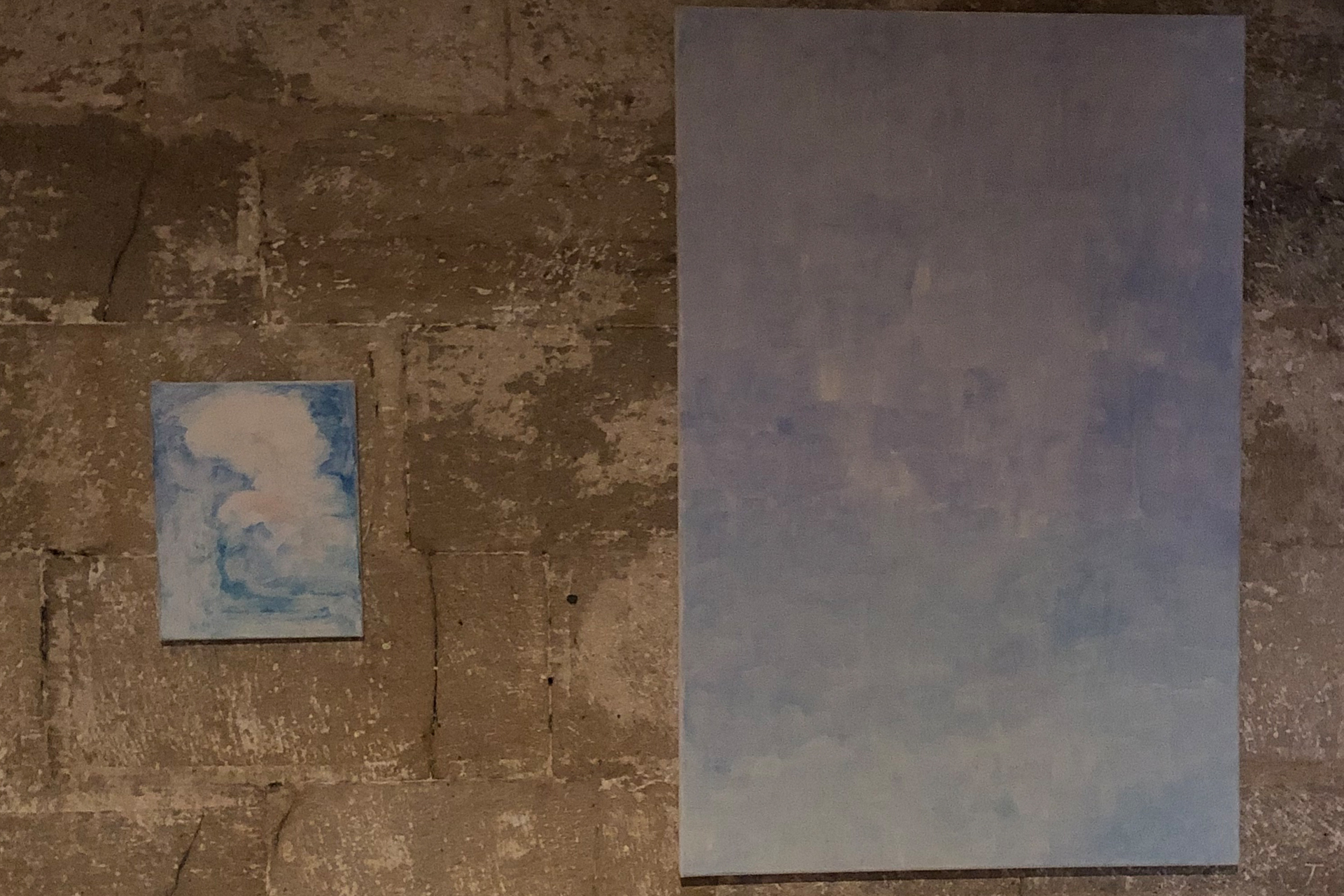 En liten och en stor målning i blått på en stenvägg.