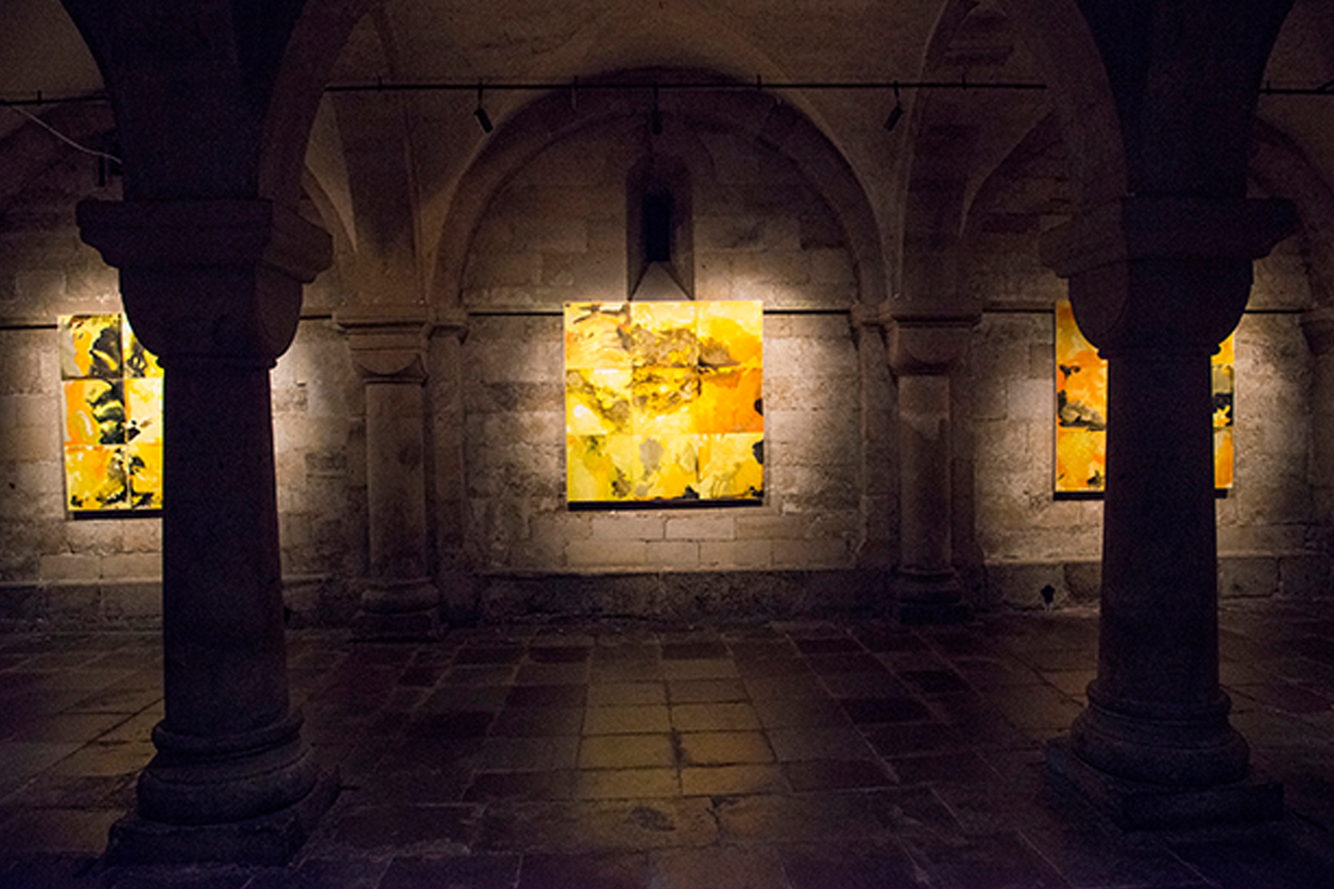 Tre tavlor med mönster i gult i Domkyrkans krypta.