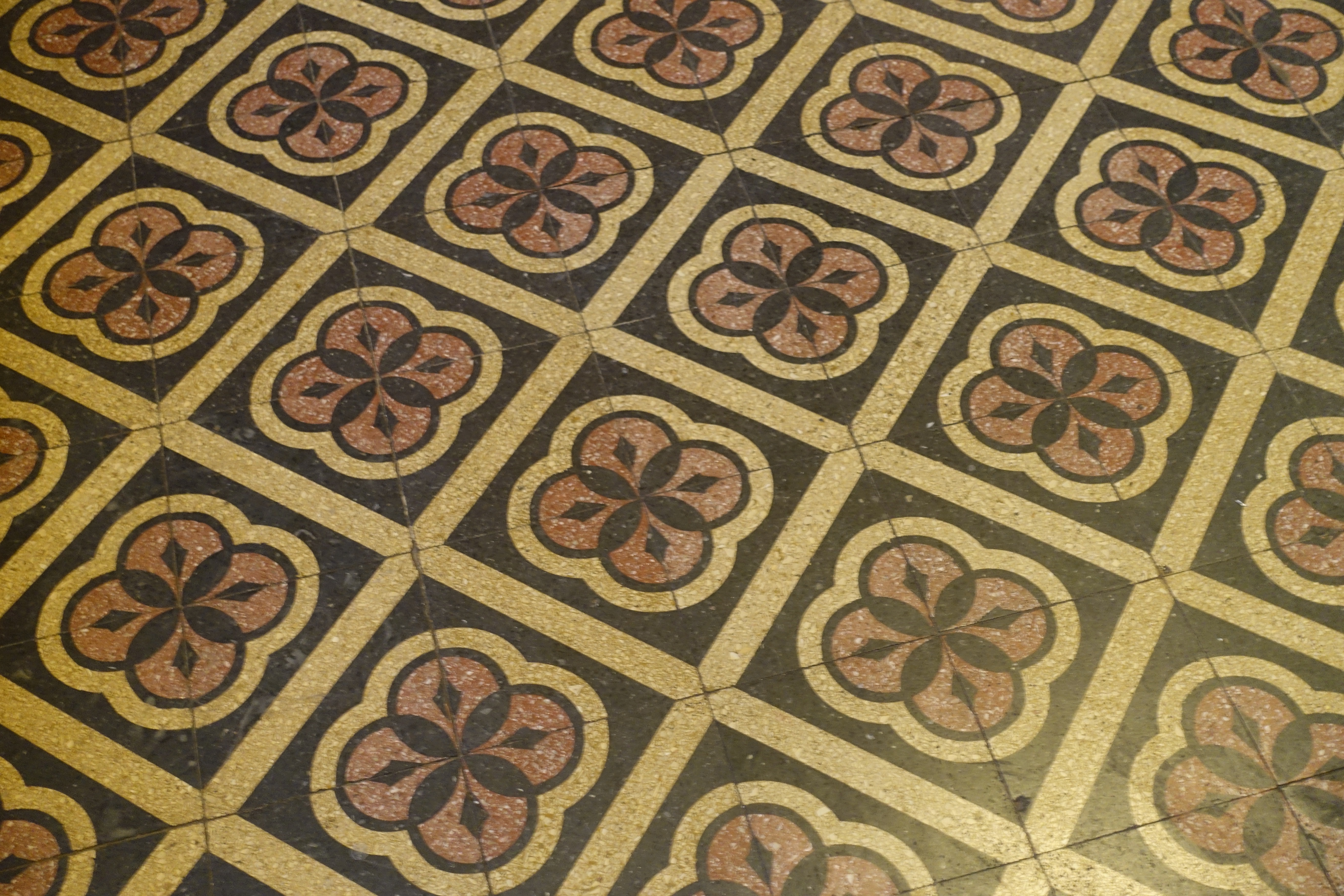 Bild på ett av kyrkans golvmönster. Svarta kvadrater med röda och svarta mönster av cirklar i.