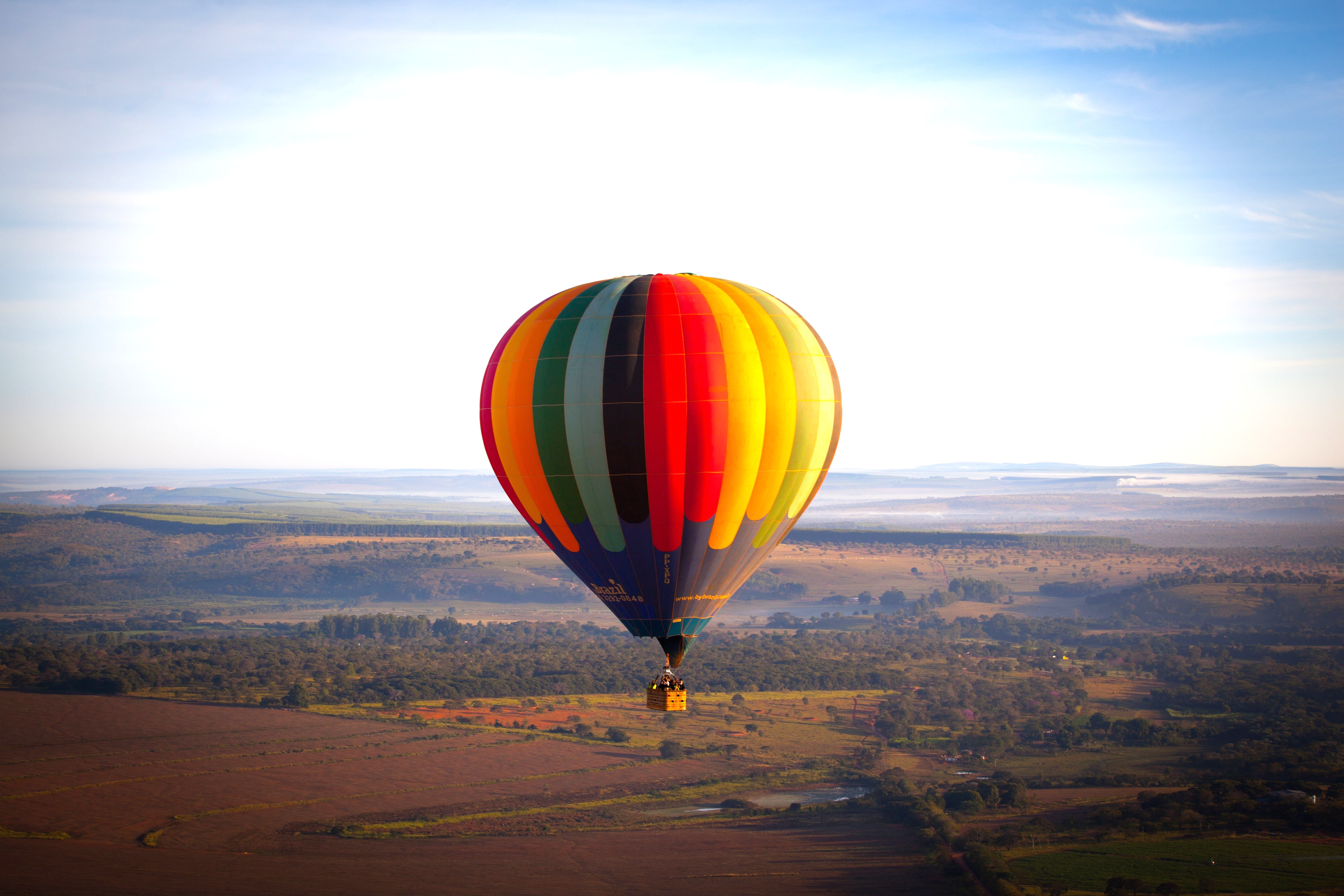 Ein bunter Heissluftballon zwischen Himmel und Erde