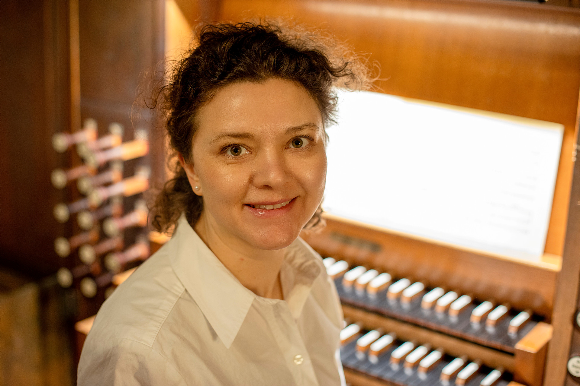 Stiftsmusiker Kira Lankinen sitter vid en orgel