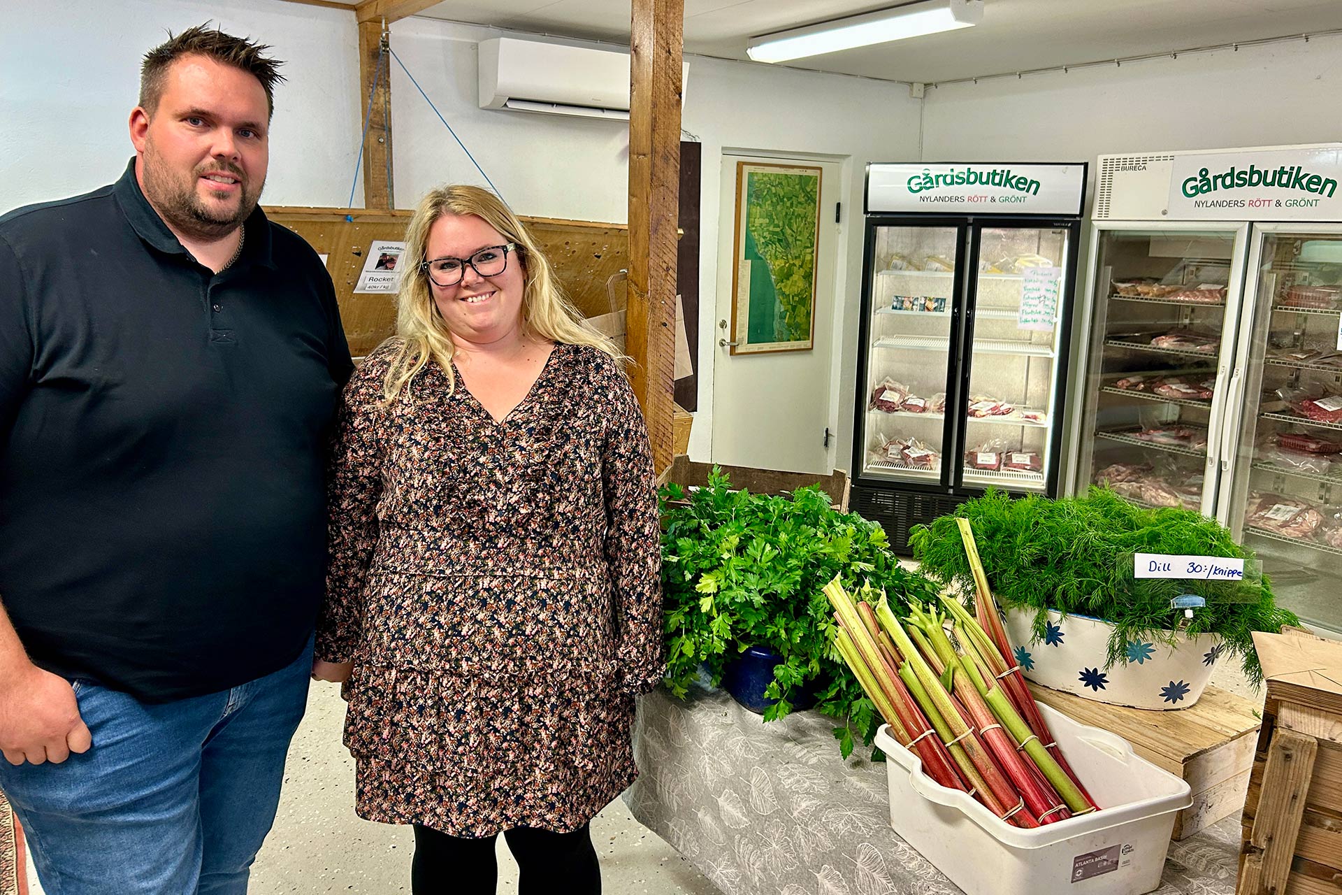 En man och en kvinna står invid ett bord med grönsaker.