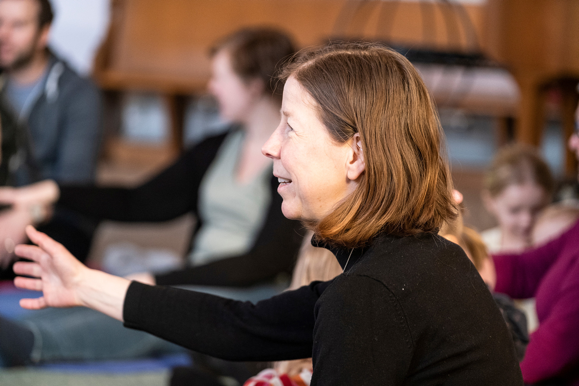 Vuxna och barn samlas i en kyrklokal för att sjunga tillsammans.