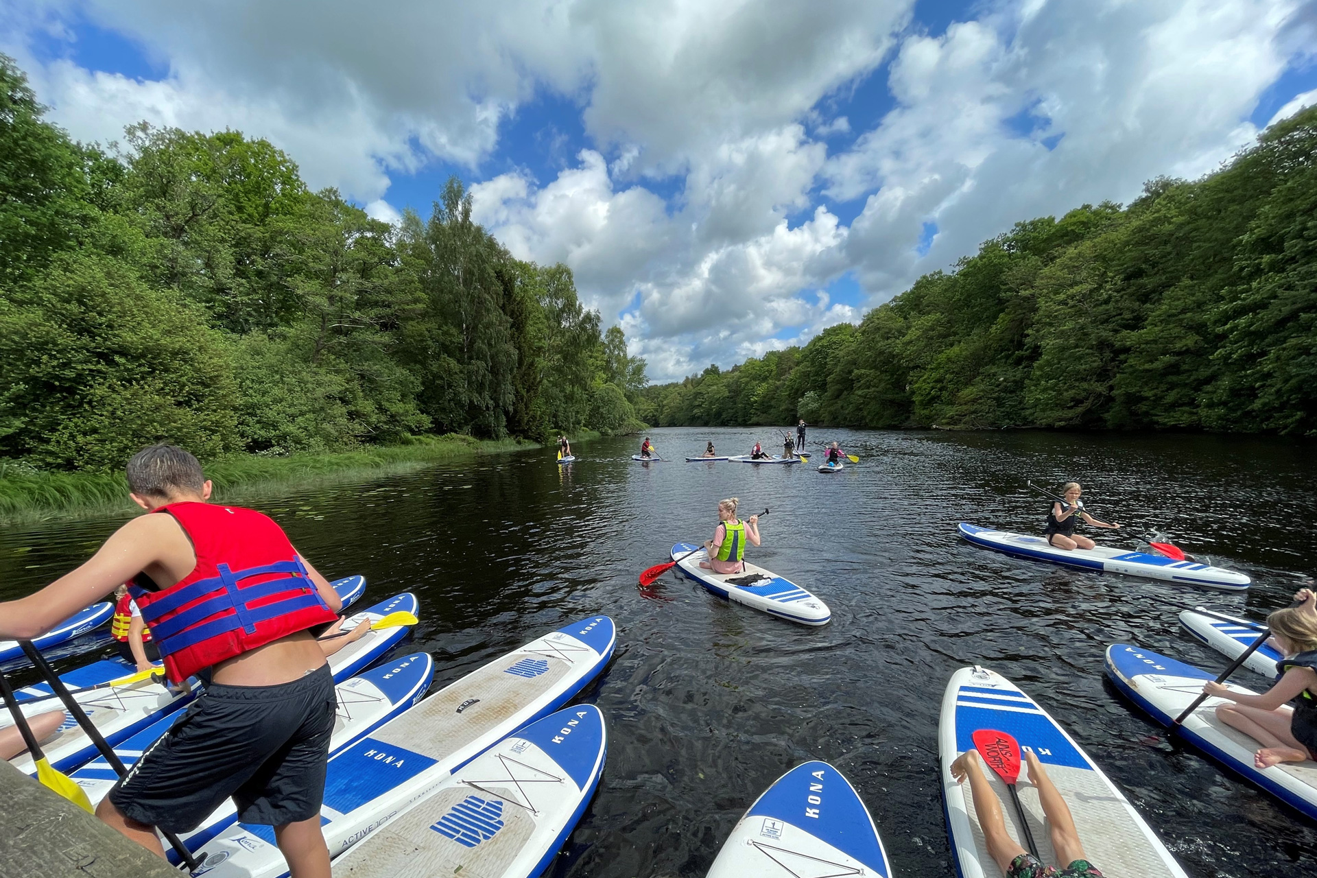 Barn och ungdomar i Harplinge-Steninge församling testar på sommaraktiviteten SUP, Stand Up Paddle, i Nissan. 