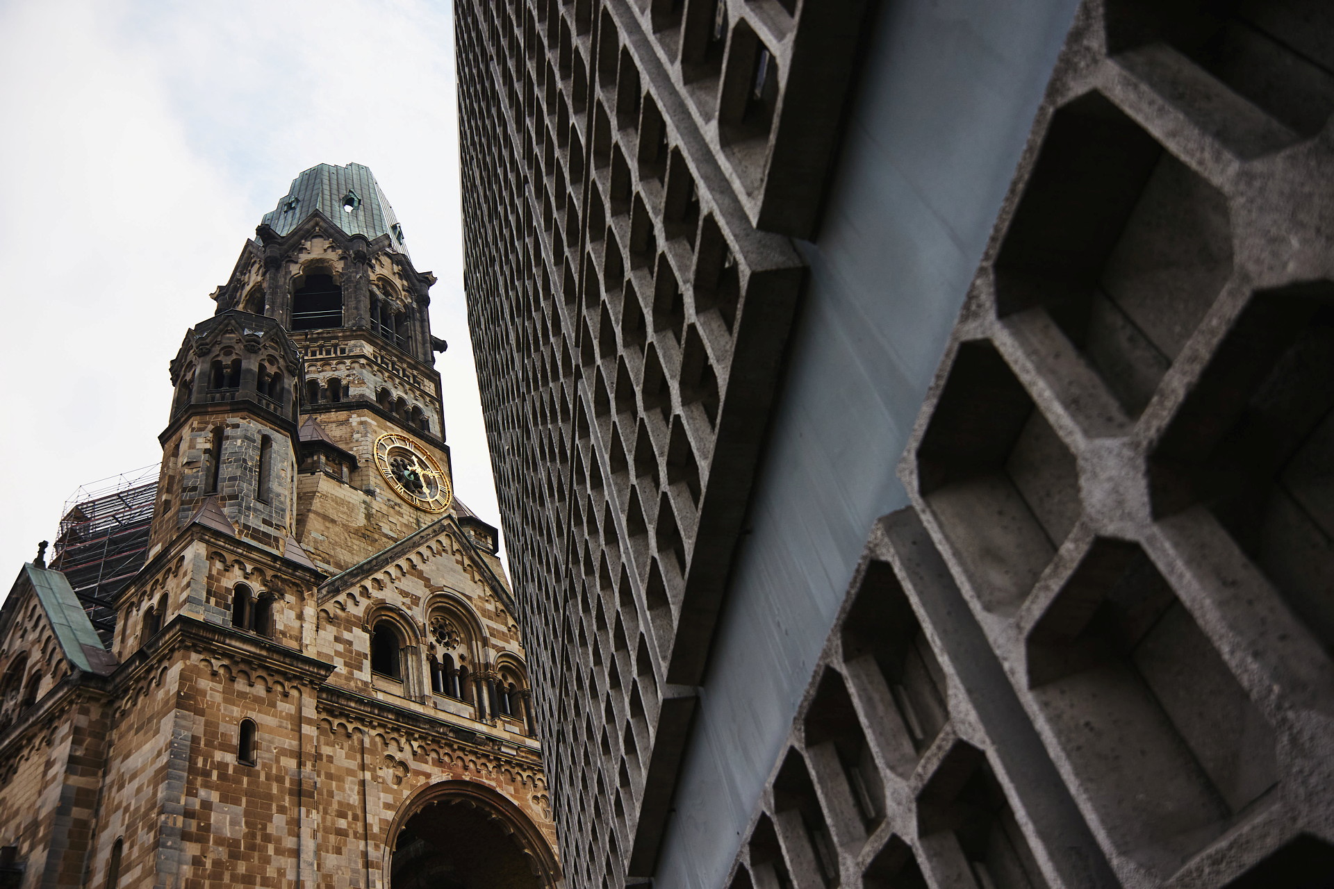 Ett kyrktorn i Berlin syns bakom en kantig byggnad.