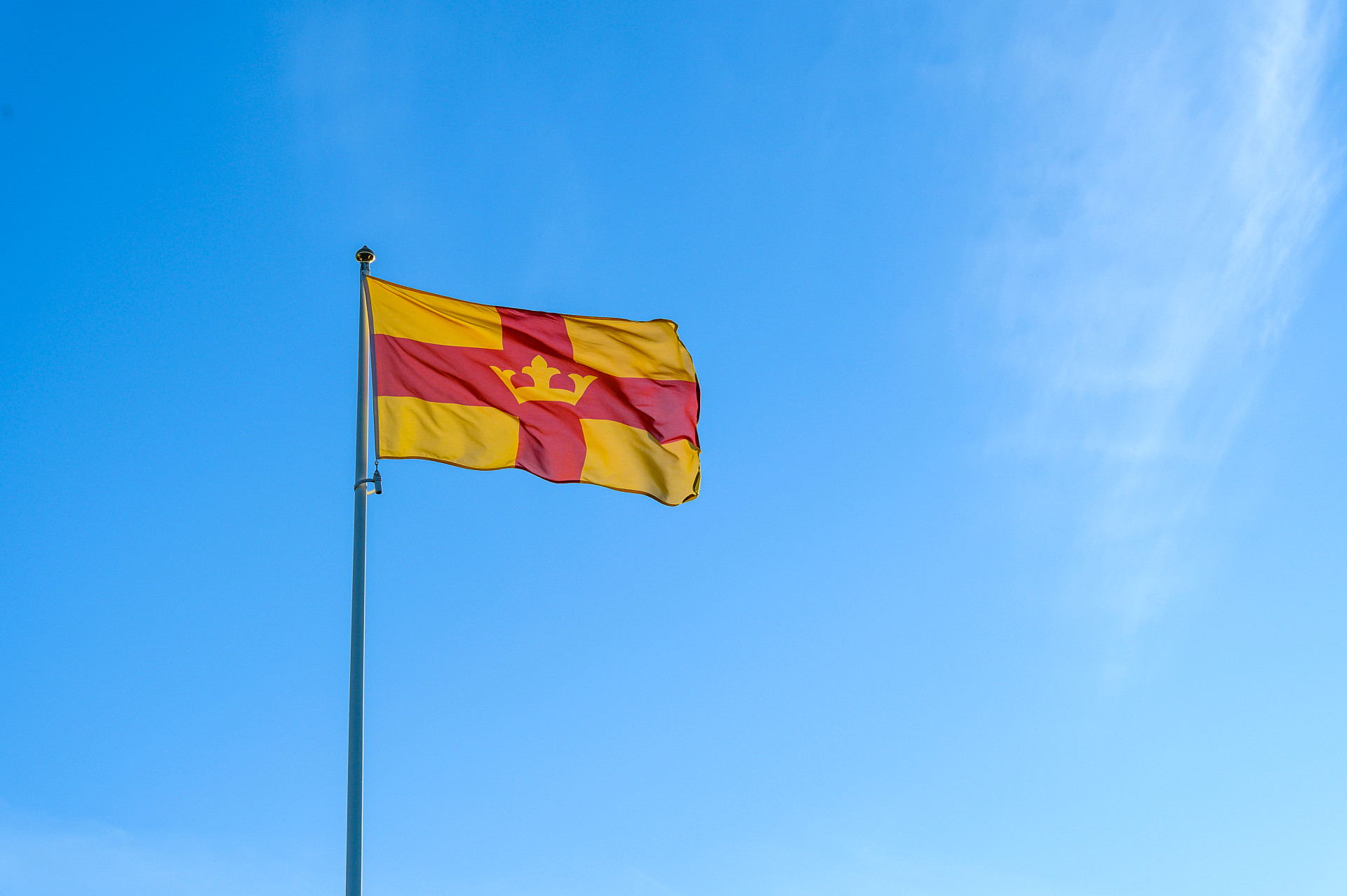 Svenska kyrkans flagga mot blå himmel.