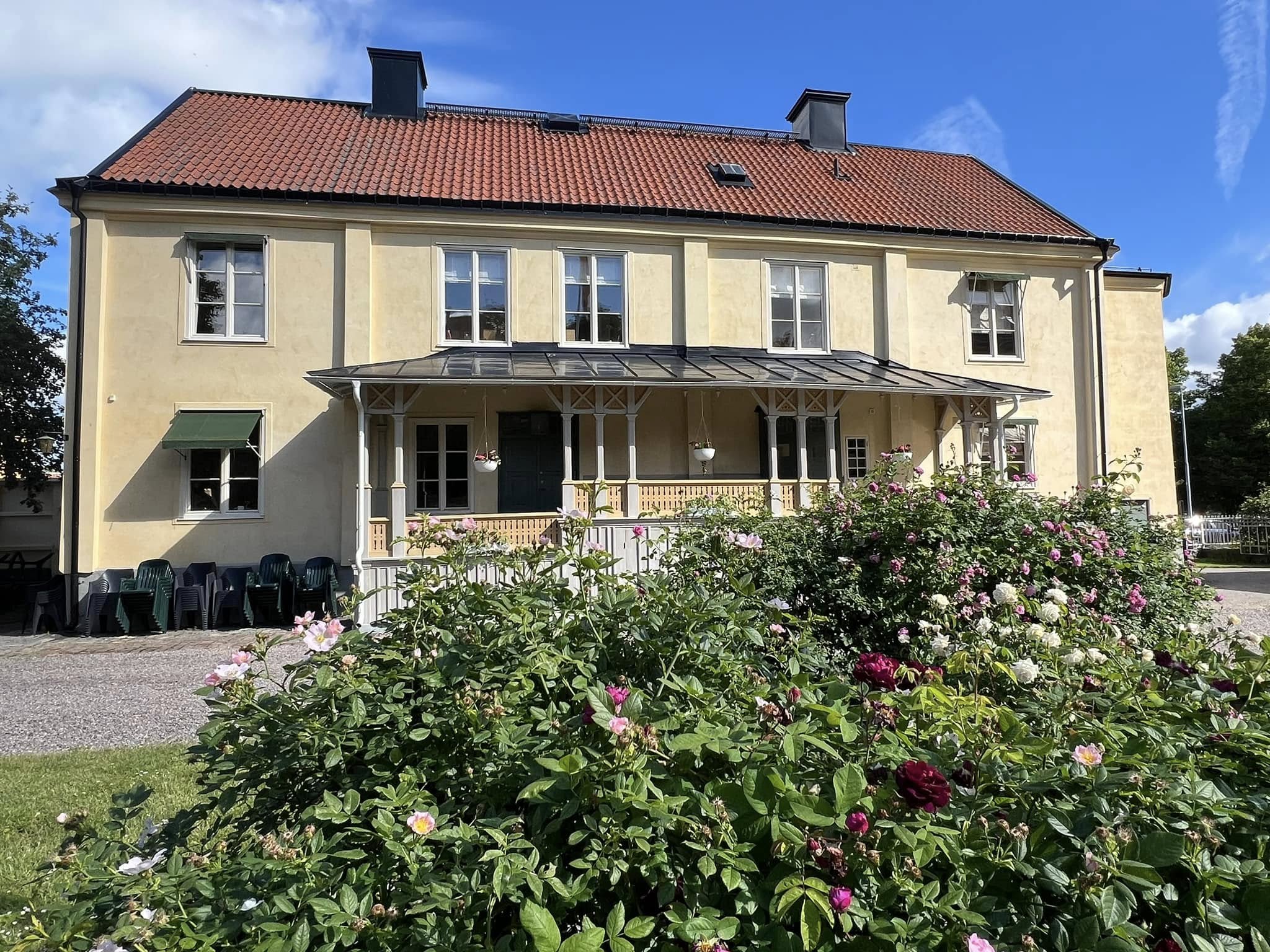 Hedvigs prästgård om sommaren med blommande rosor