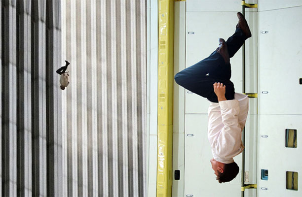 The falling man. Konstverk. En man ser ut att fall rakt ner längs en husvägg, i fönstret syns hans spegelbild.