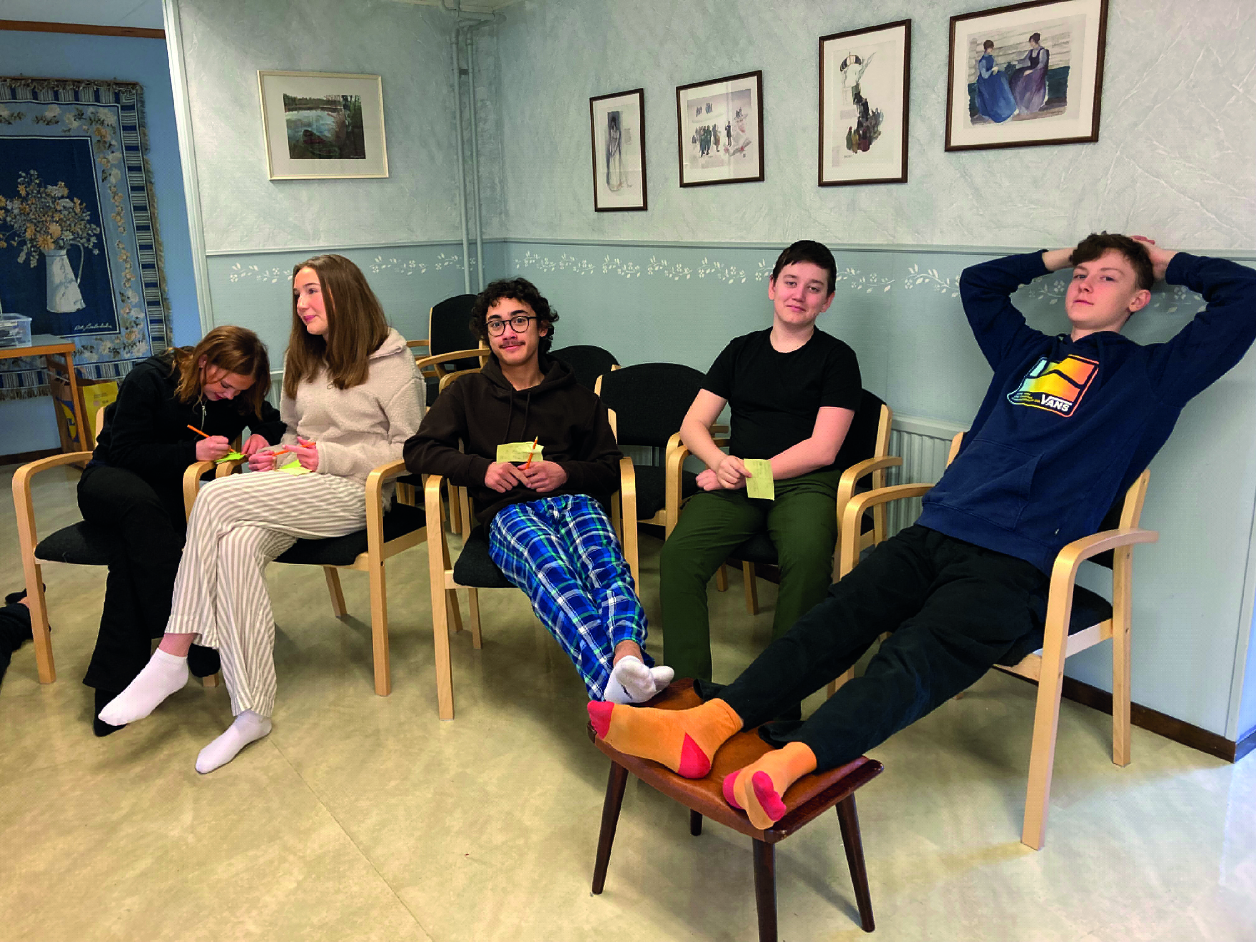 Konfirmander chillar i var sin stol och ser avslappnade ut.