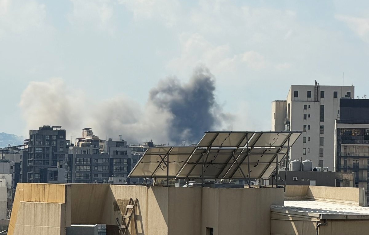 Rökmoln som stiger över stadsmiljö