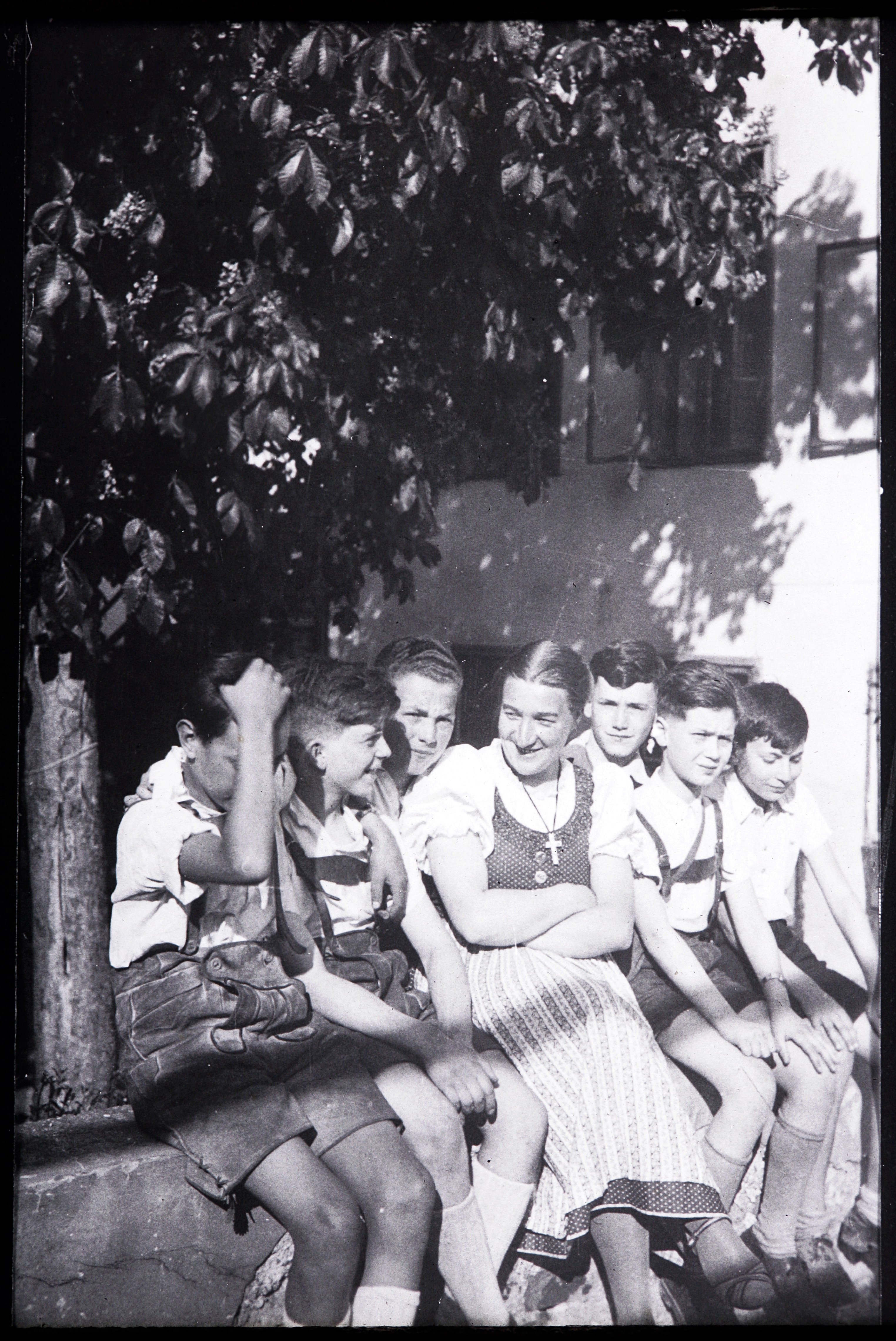 En kvinna och några barn sitter på en mur.