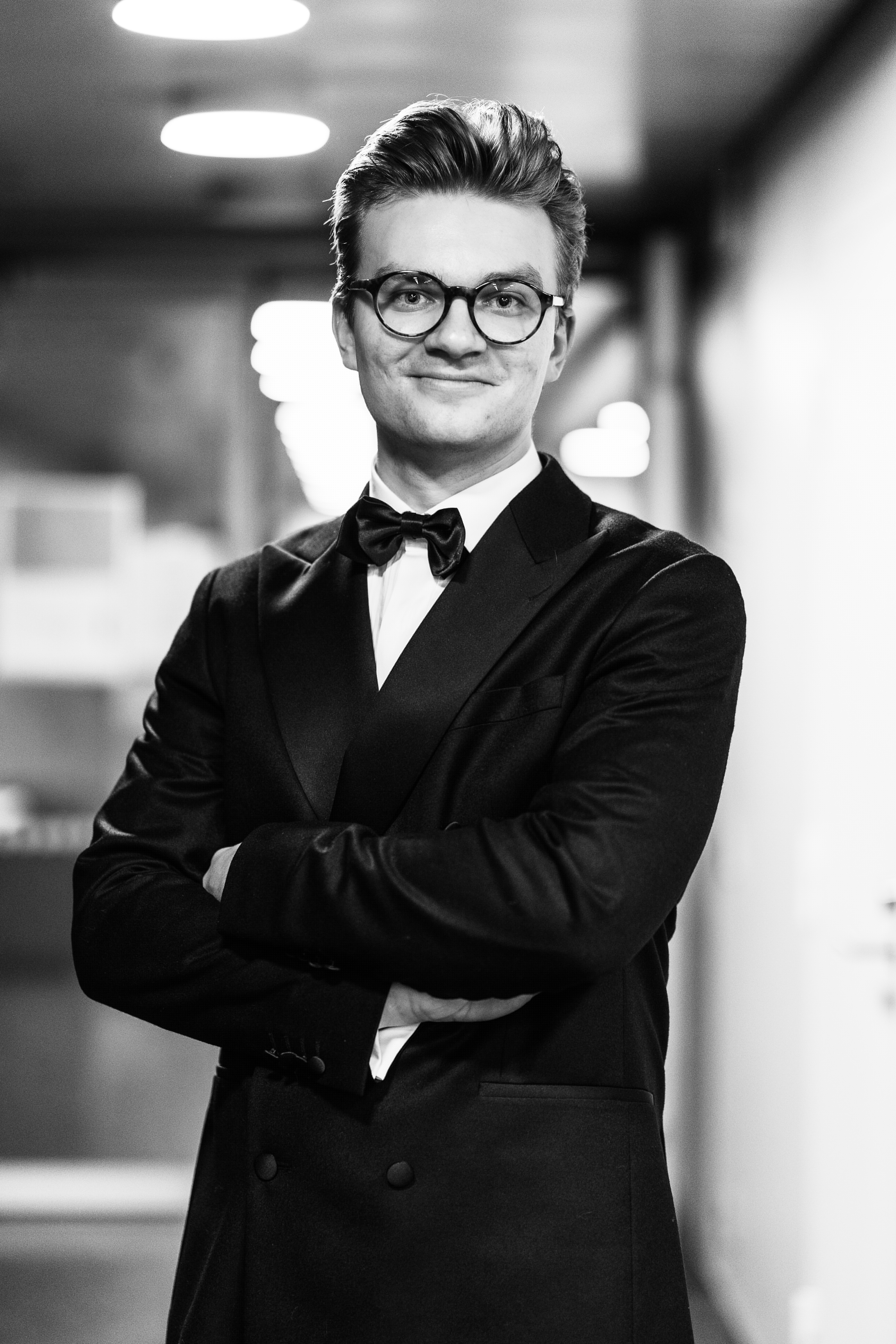svartvit bild på man i kostym med armarna i kors halvporträtt