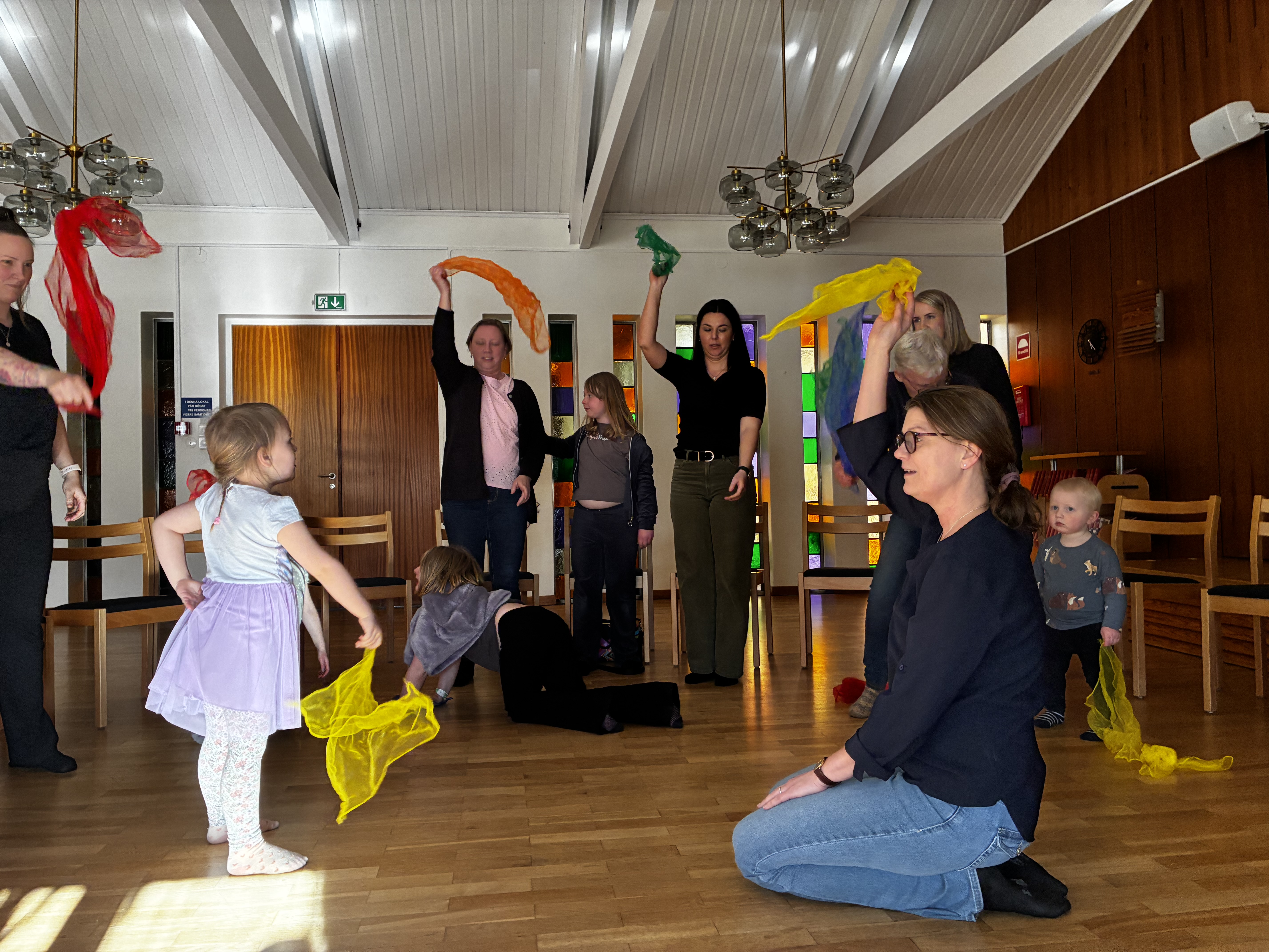 barn och vuxna leker och dansar med sjalar