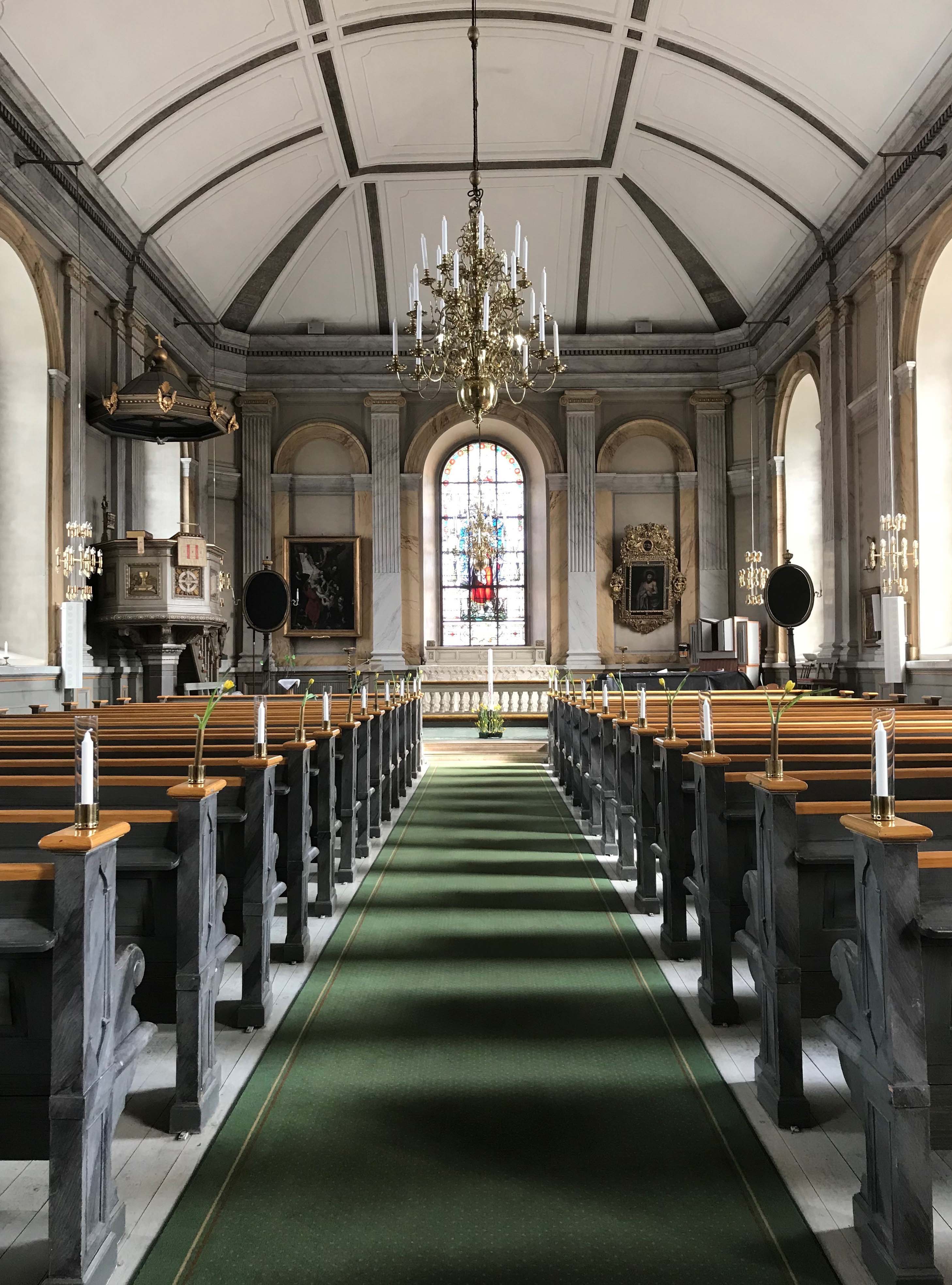 Vaxholms kyrka med bänkar och gång mot koret.