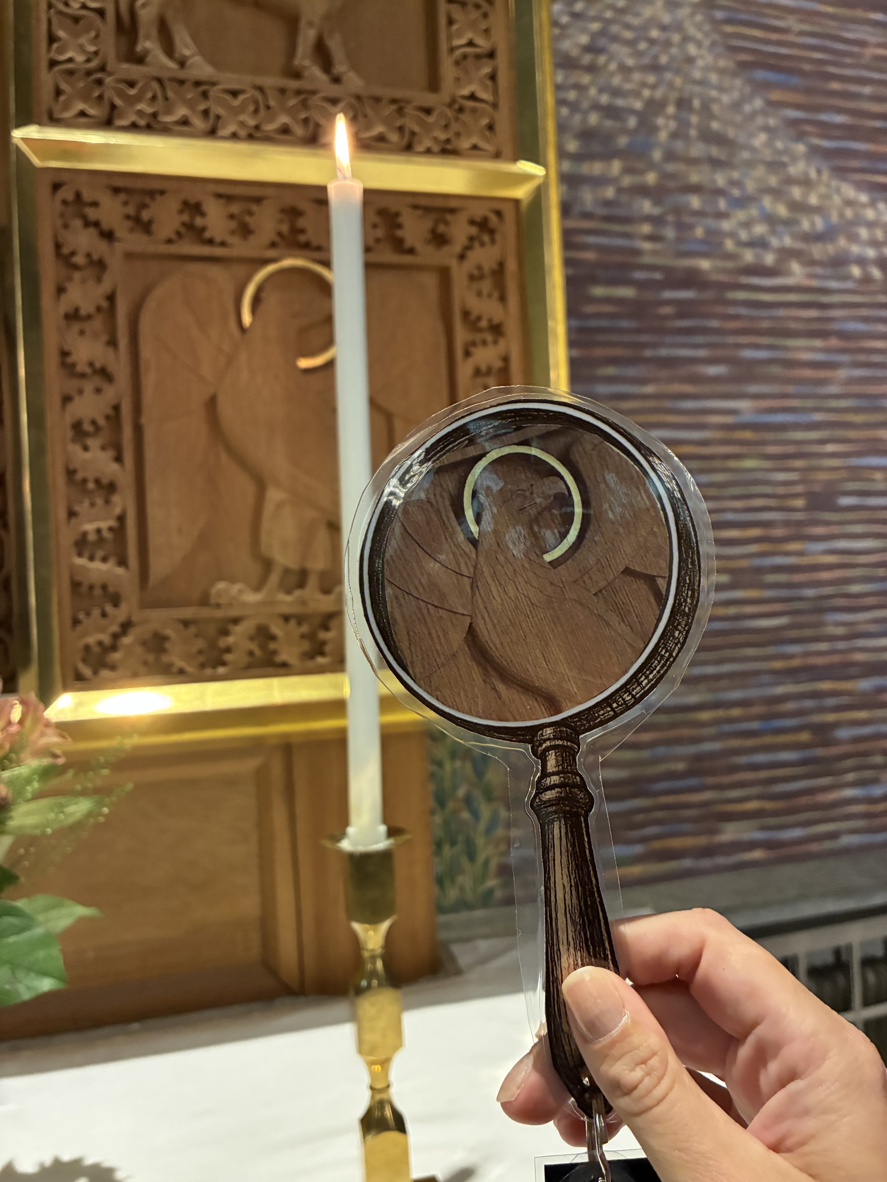 Du ser en del av altartavlan i Gustav Adolfs kyrka genom ett förstoringsglas