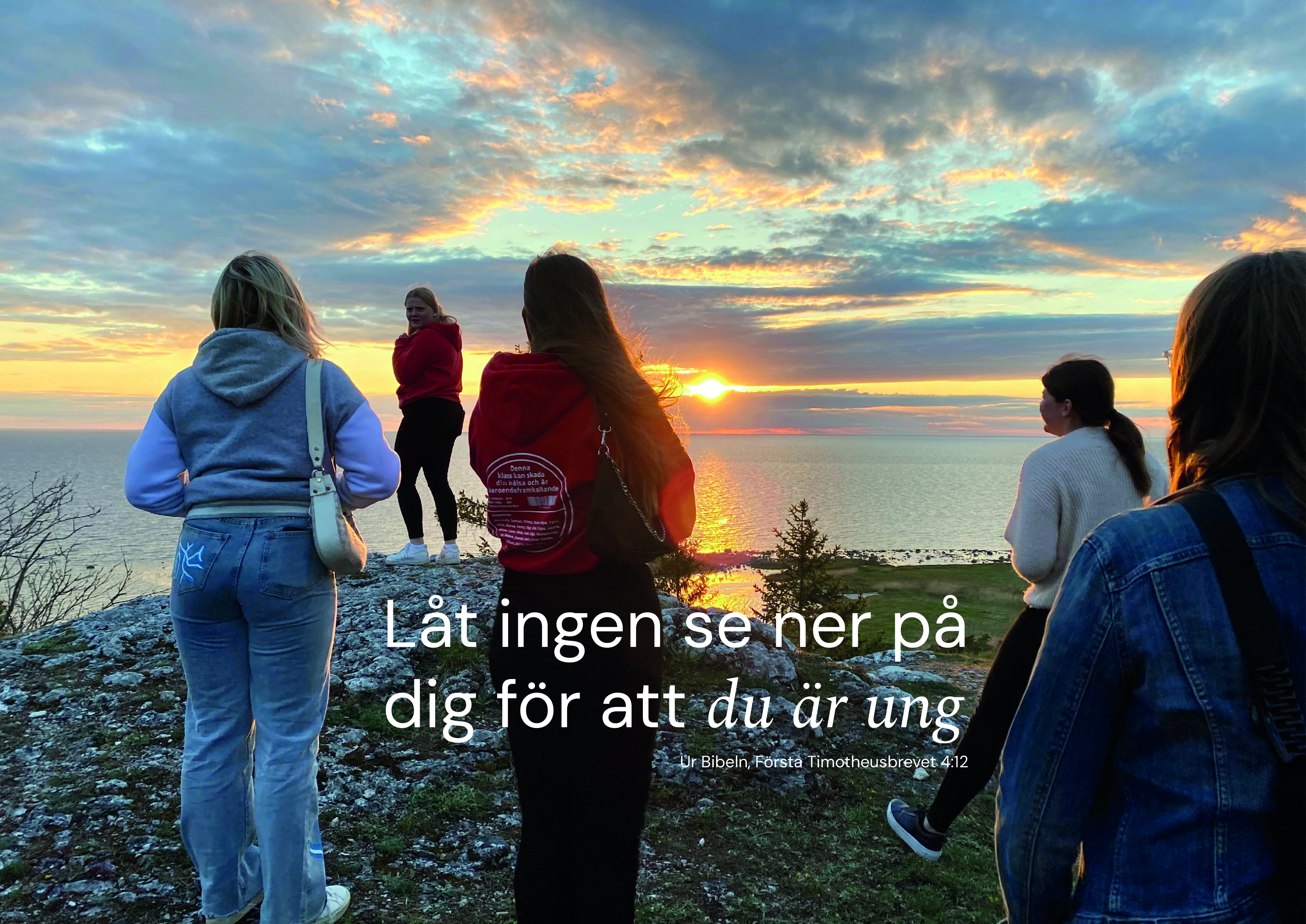 Ungdomar vid en klintkant, blickar ut över solnedgången. Det blåser i deras hår. 