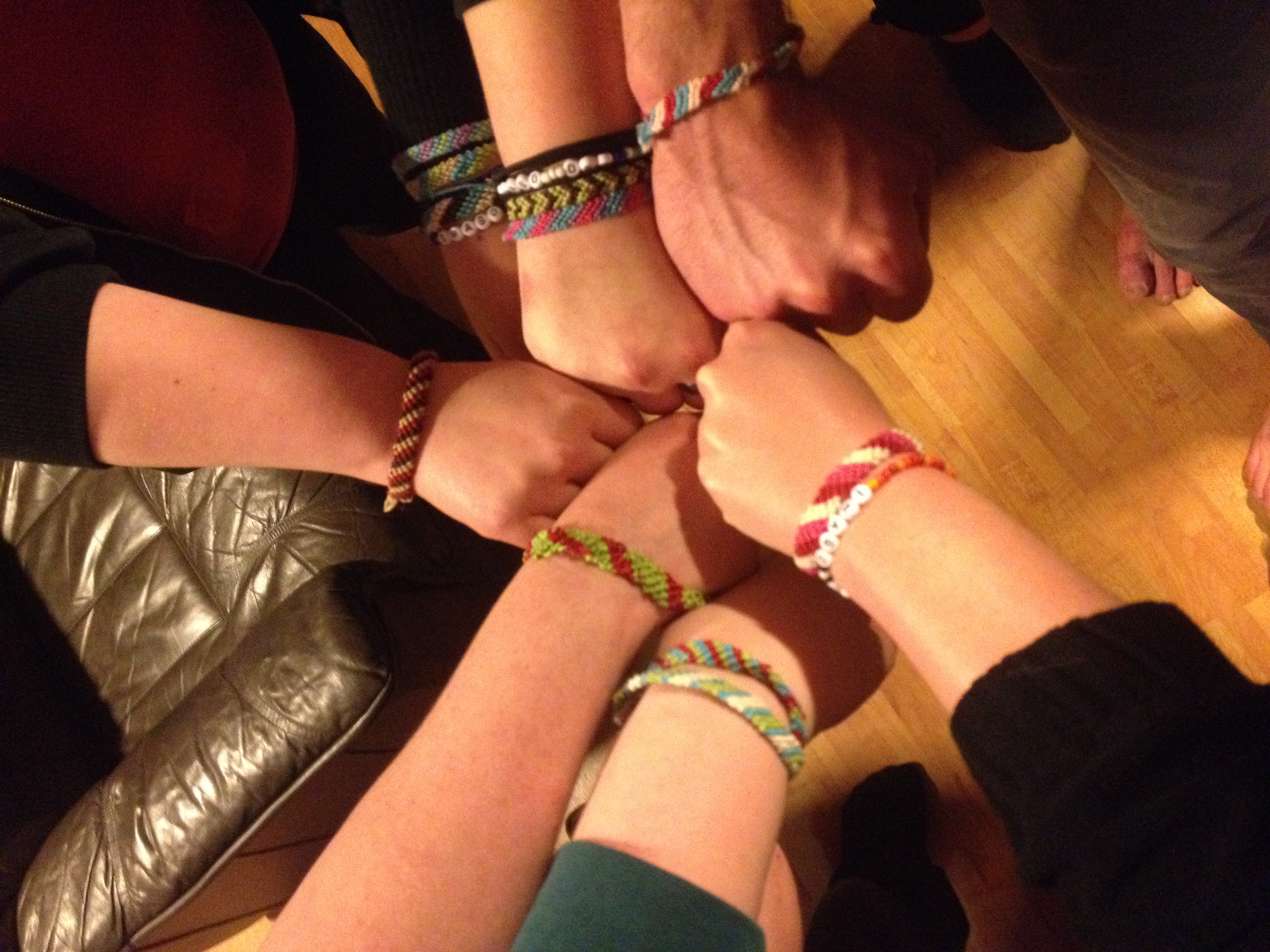 Knutna händer som hålls mot varandra med pärlade armband