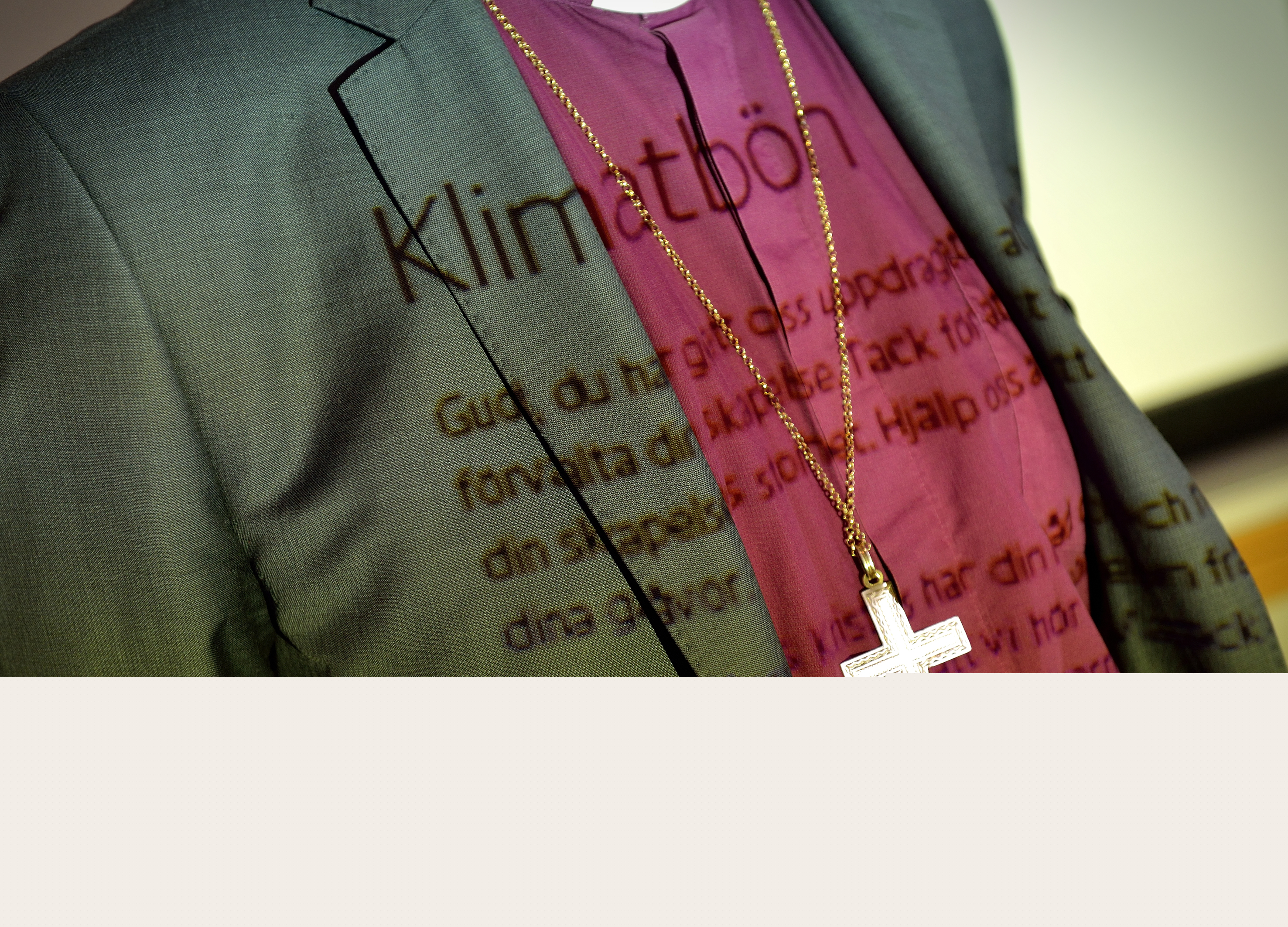 Texten till en klimatbön projicerad på en biskops kläder.