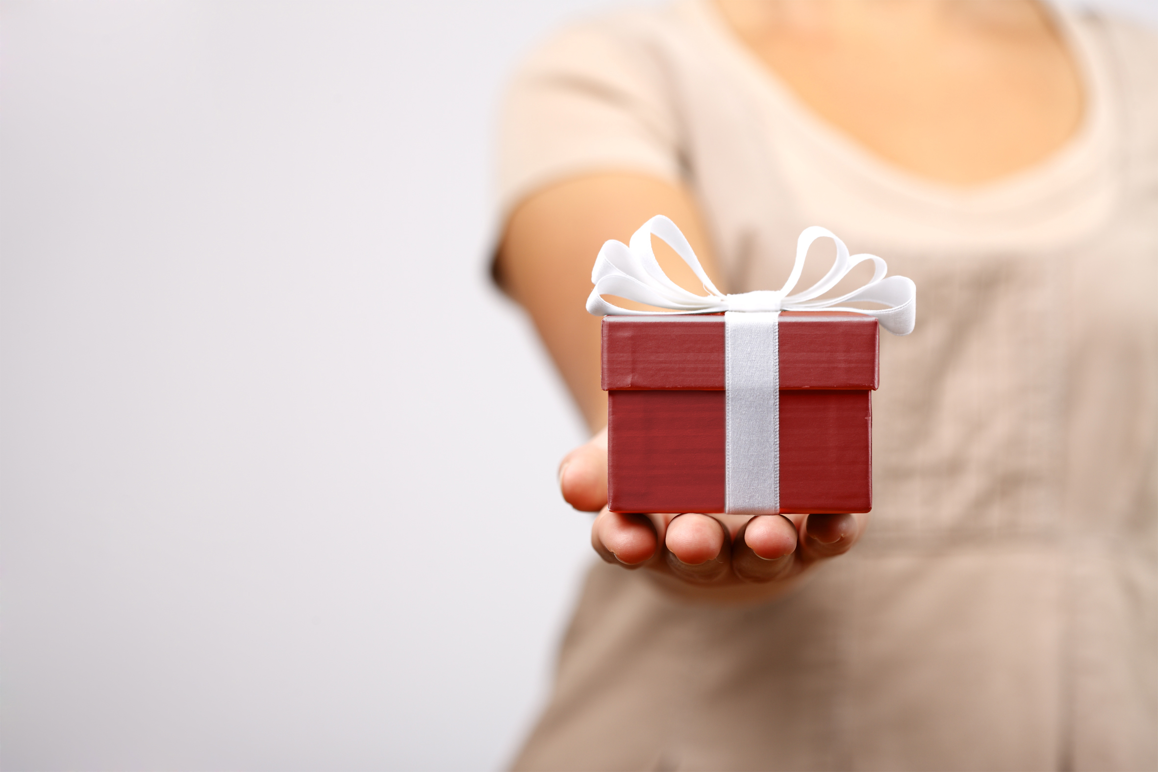 Någon sträcker fram ett litet rött paket.