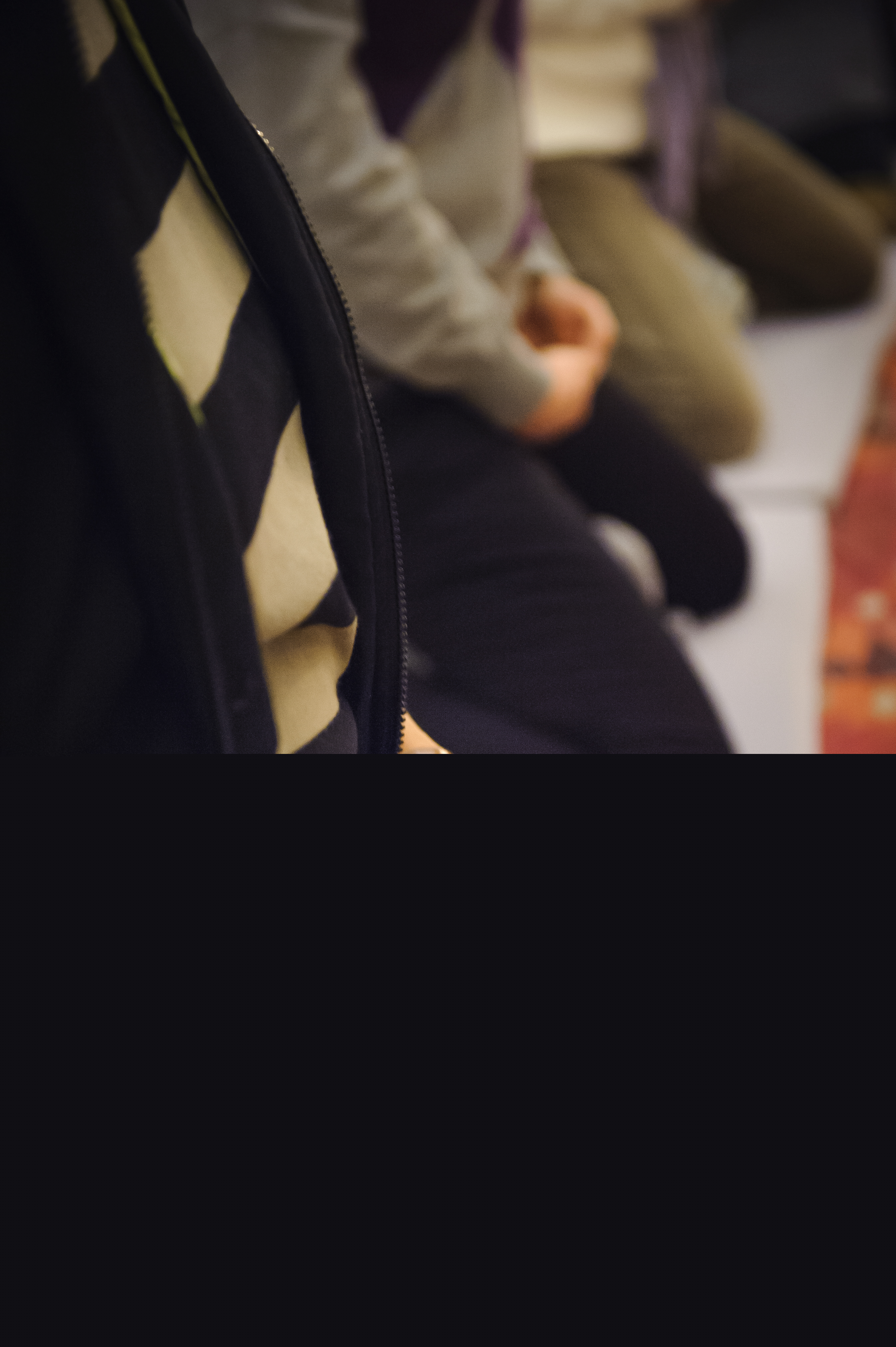 Några personer sitter på knä på golvet med knäppta händer.