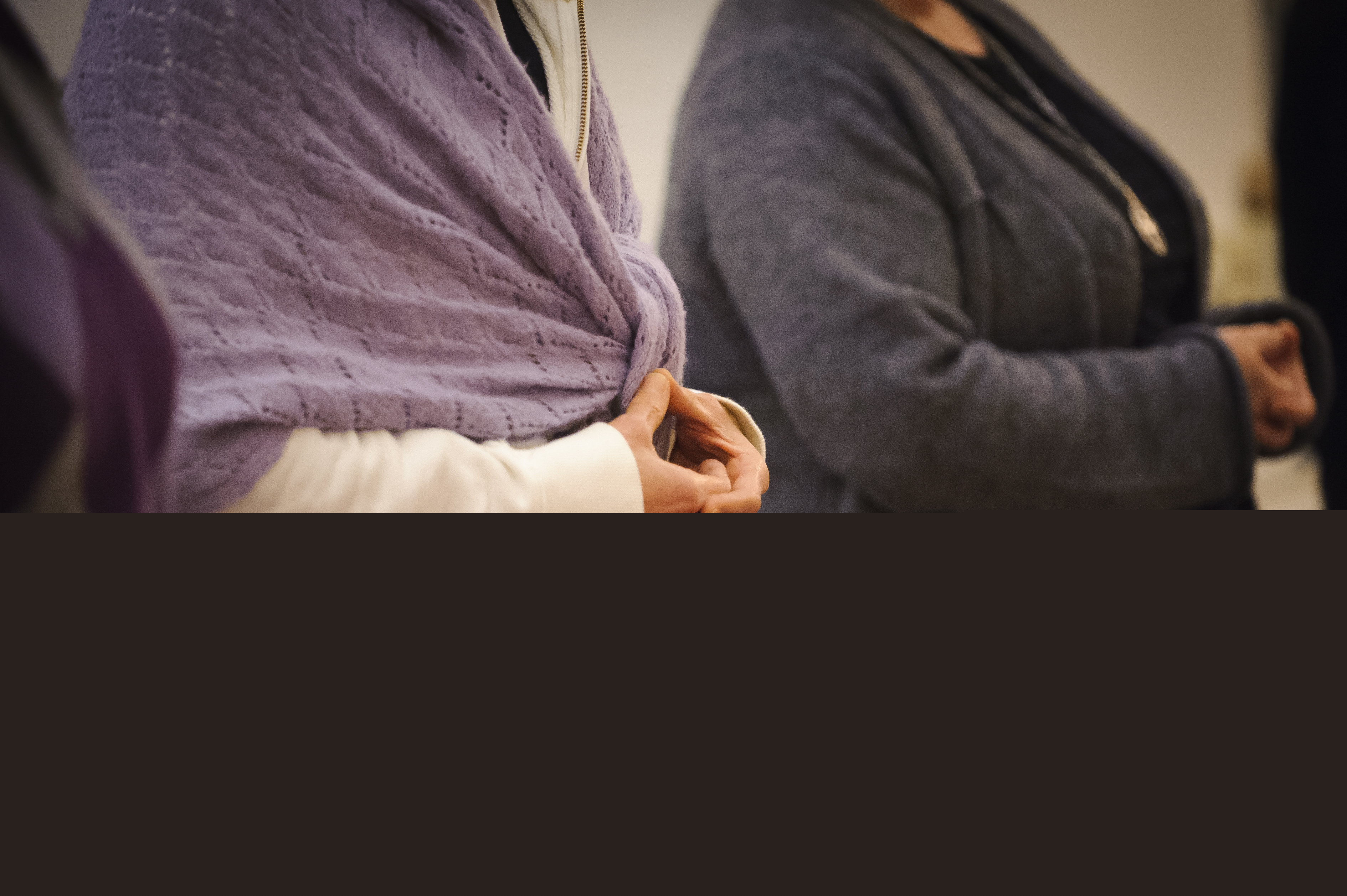 Två personer sitter på knä med knäppta händer.