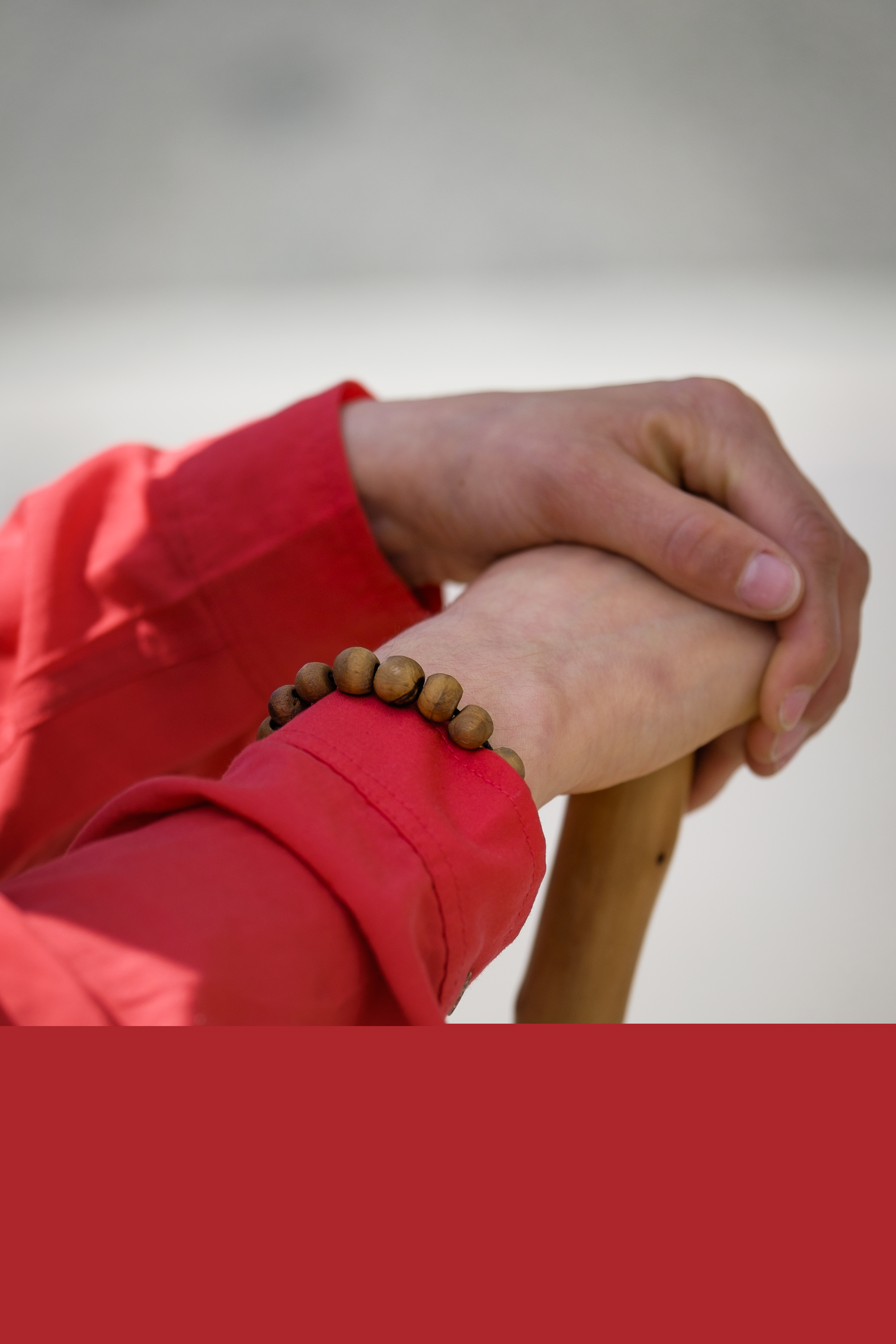 Någon vilar händerna på en käpp.