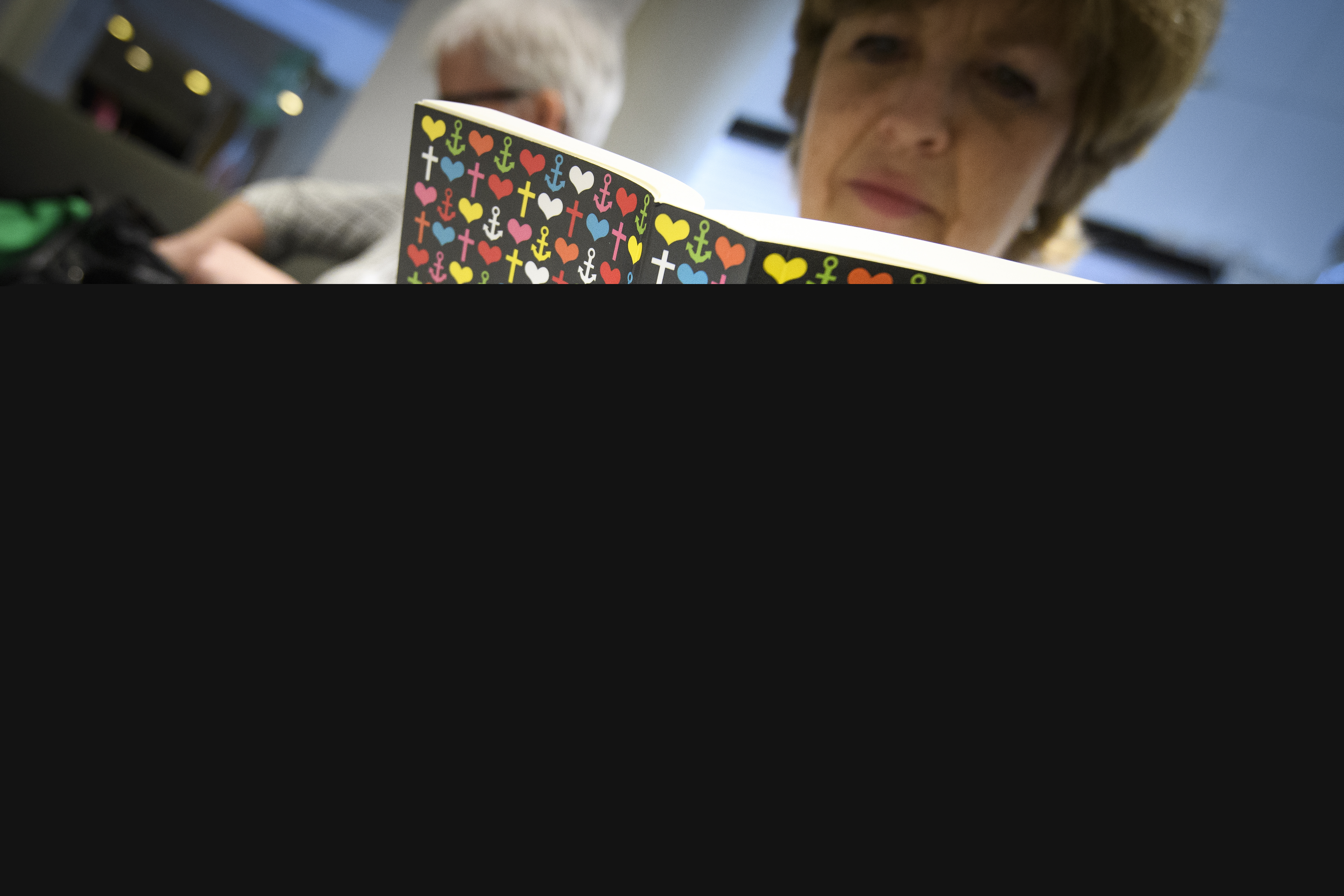 En äldre kvinna läser en bibel.